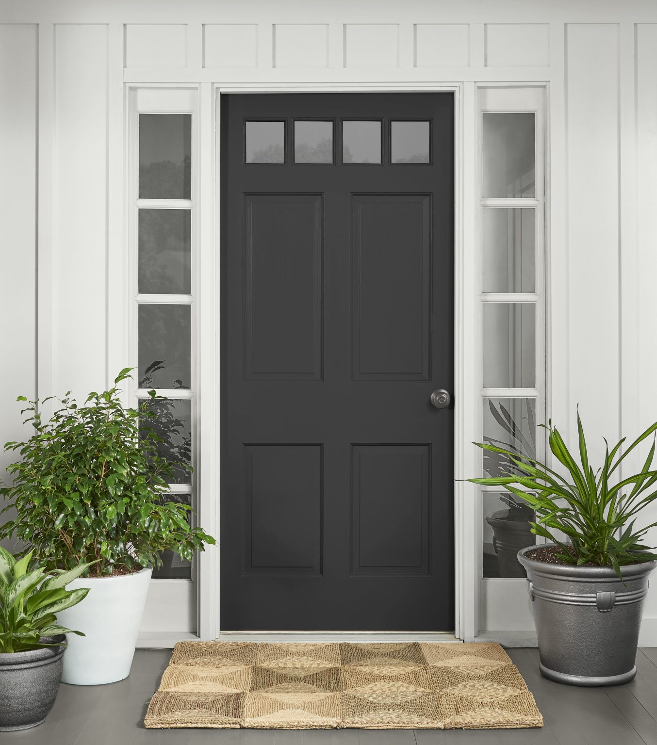 The exterior of a white house with the front door painted in black