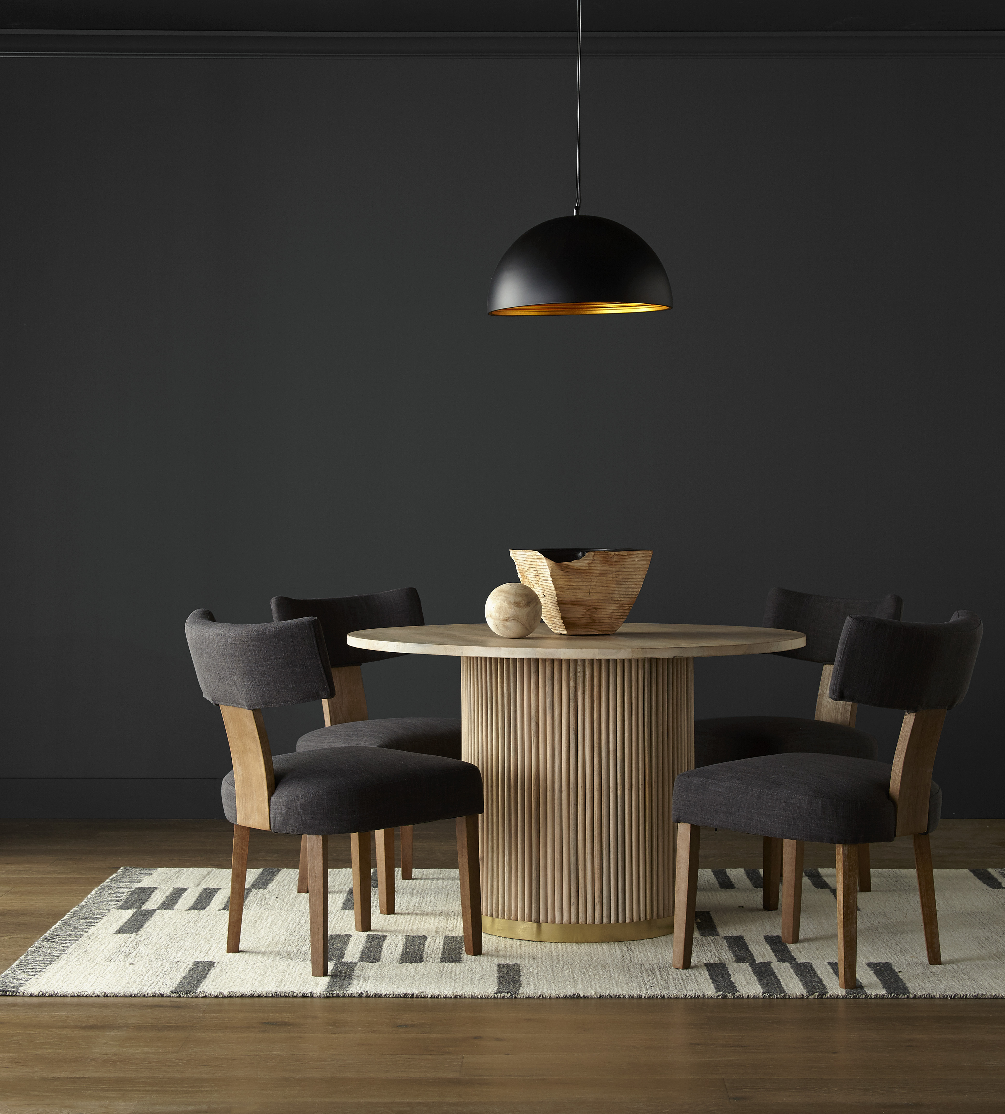 A simple and elegant dining room with walls in the colour Cracked Pepper, styled with a hanging black pendant light fixture
