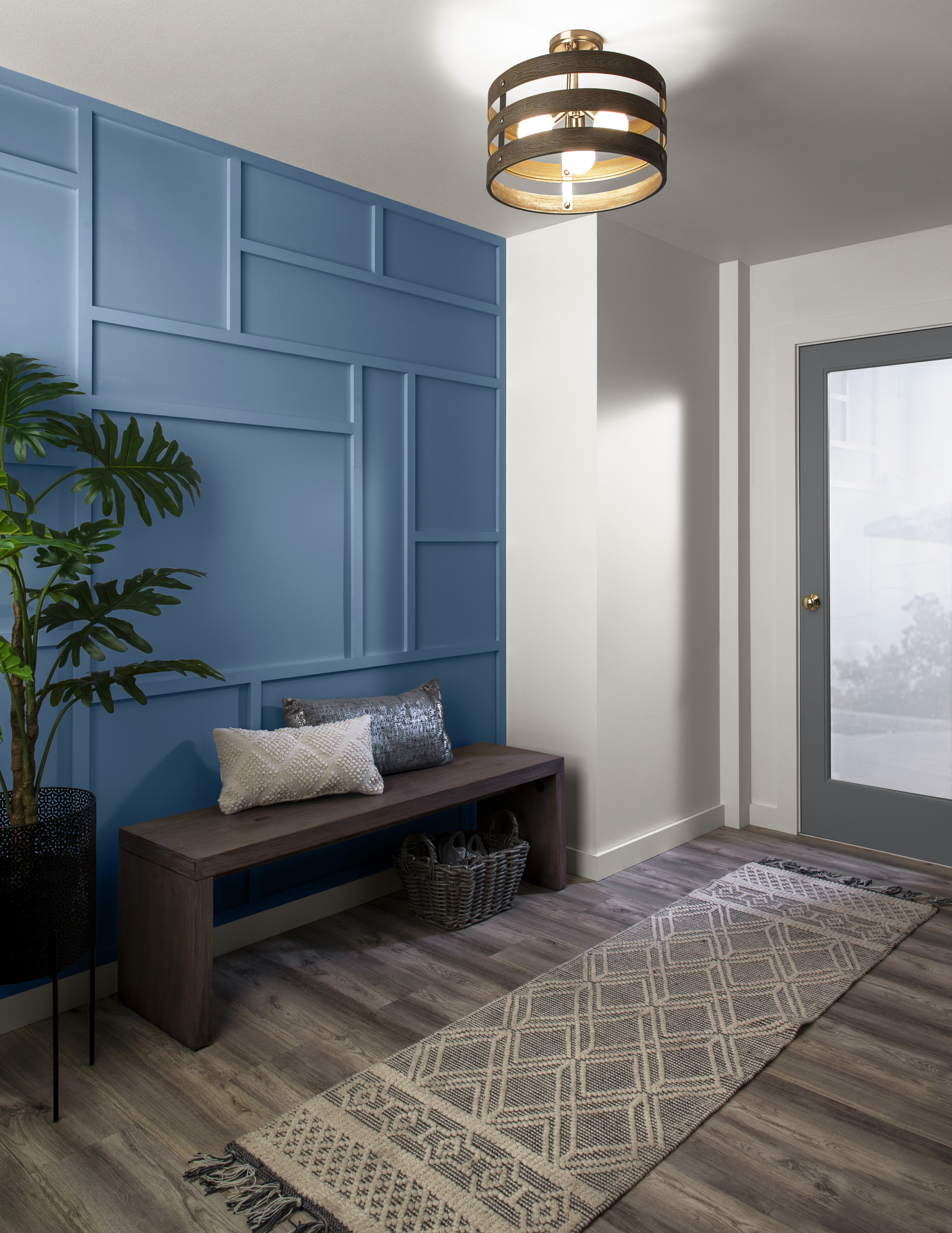 A narrow foyer with a textured accent wall in the colour Laguna Blue