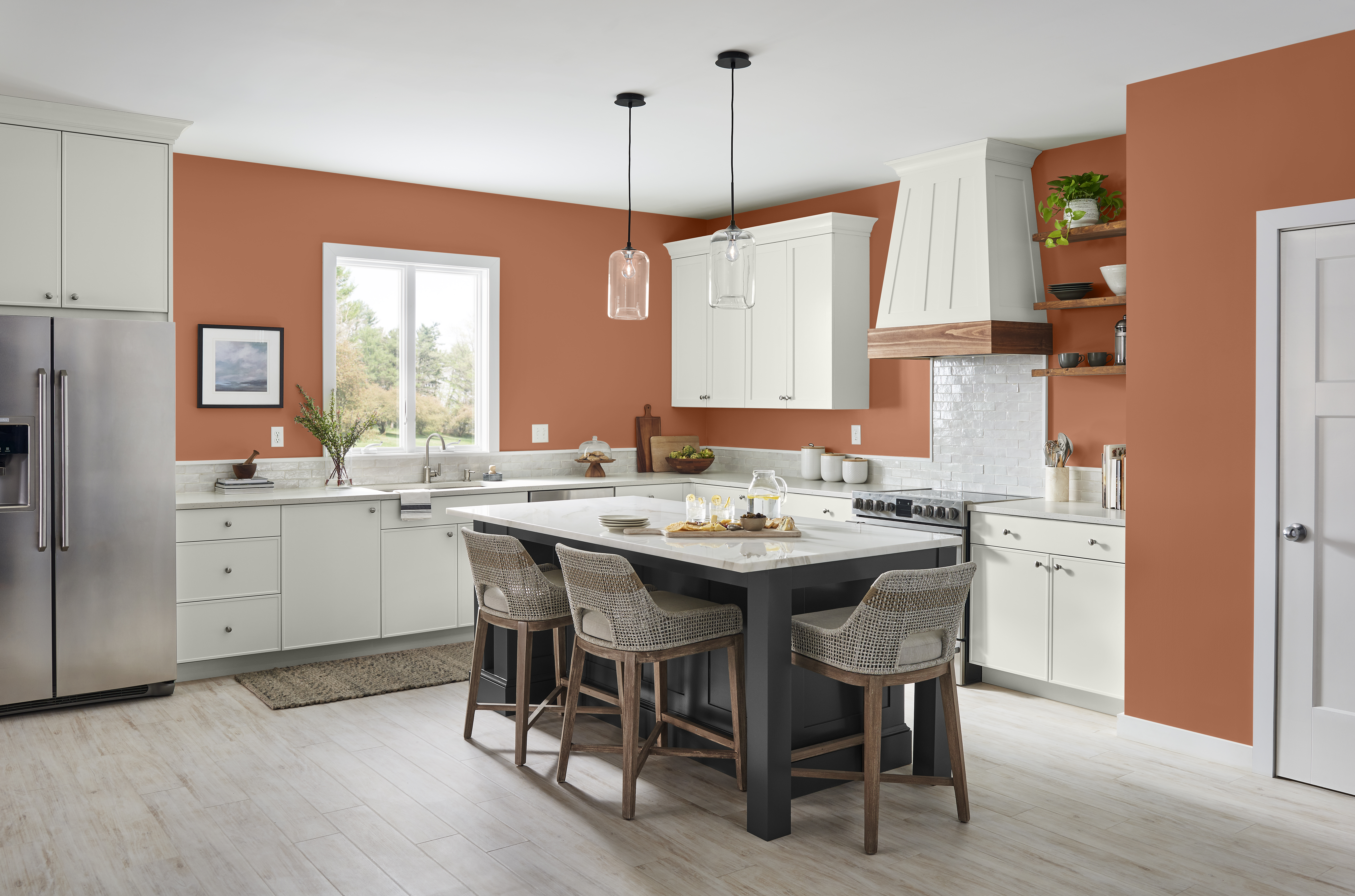 A large kitchen with walls in the colour Orange Flambe and paired with white cabinets and a black island