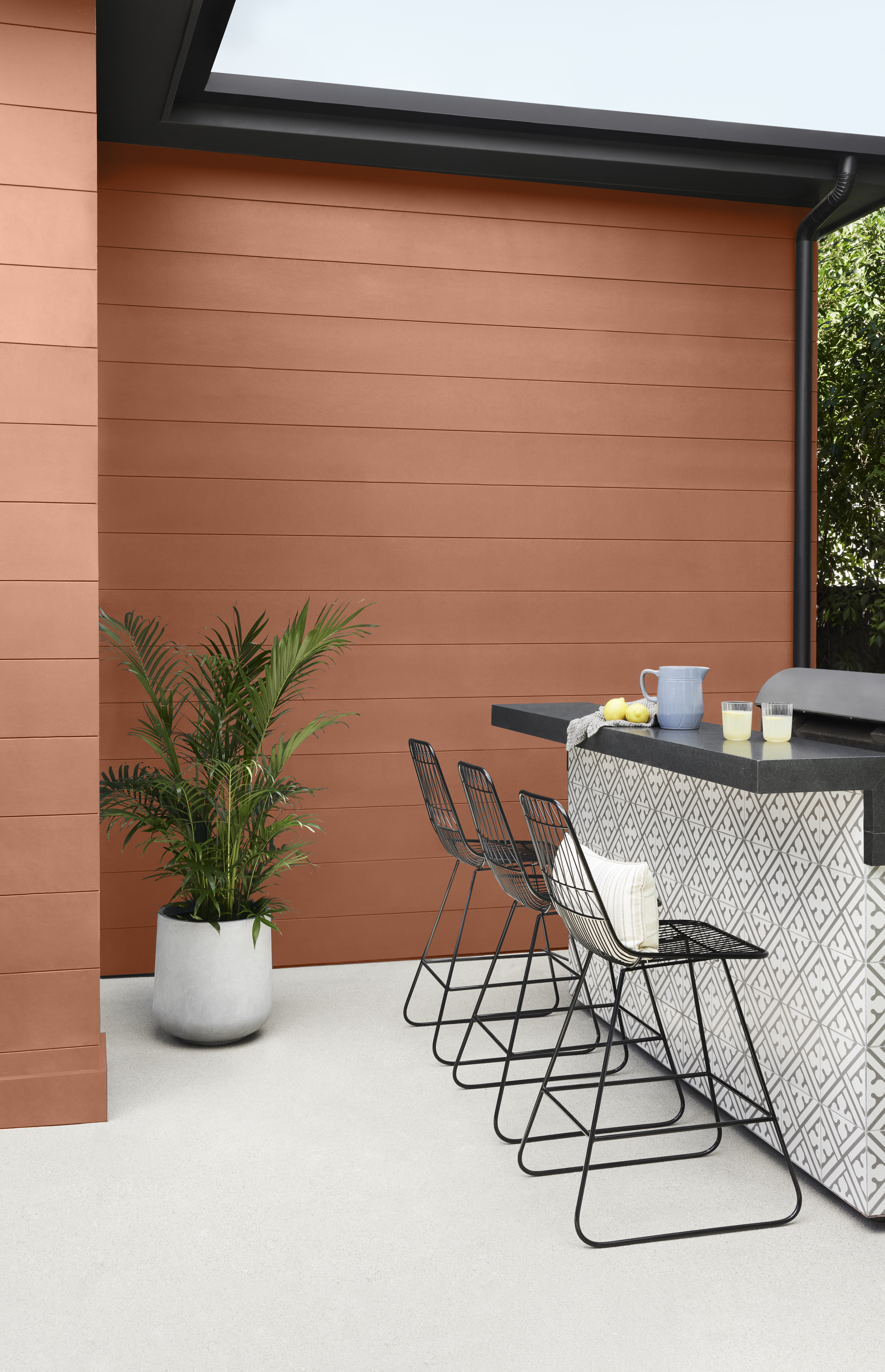 An outdoor entertainment area, with house exterior siding in the colour Orange Flambe and trim in the colour Cracked Pepper