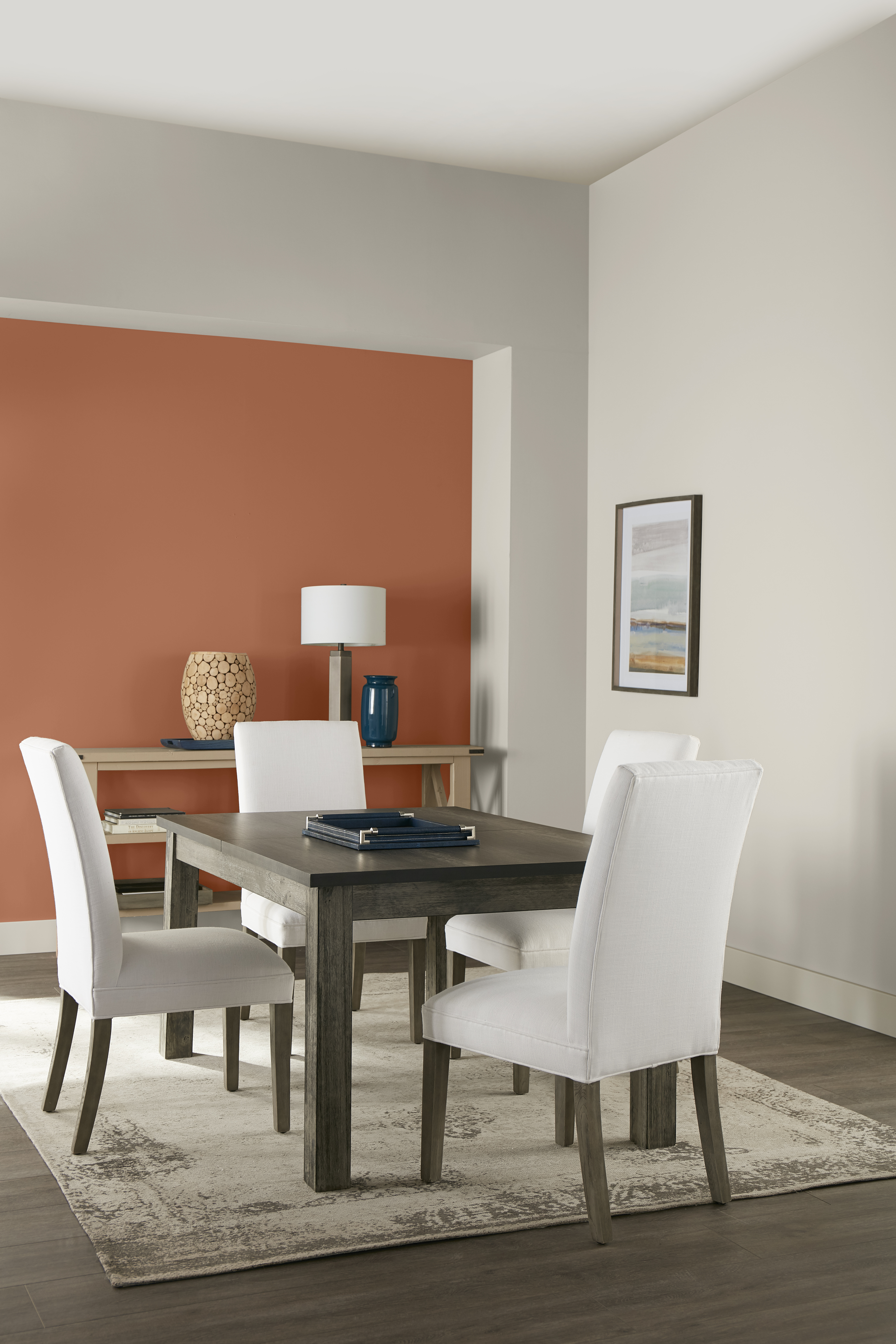 A simple and elegant dining room with walls in the colour Tranquil Gray and an accent wall in the colour Orange Flambe