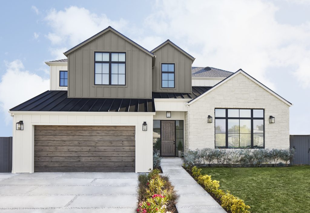 The exterior of a modern farmhouse with siding, board and batten, wood, and stone elements