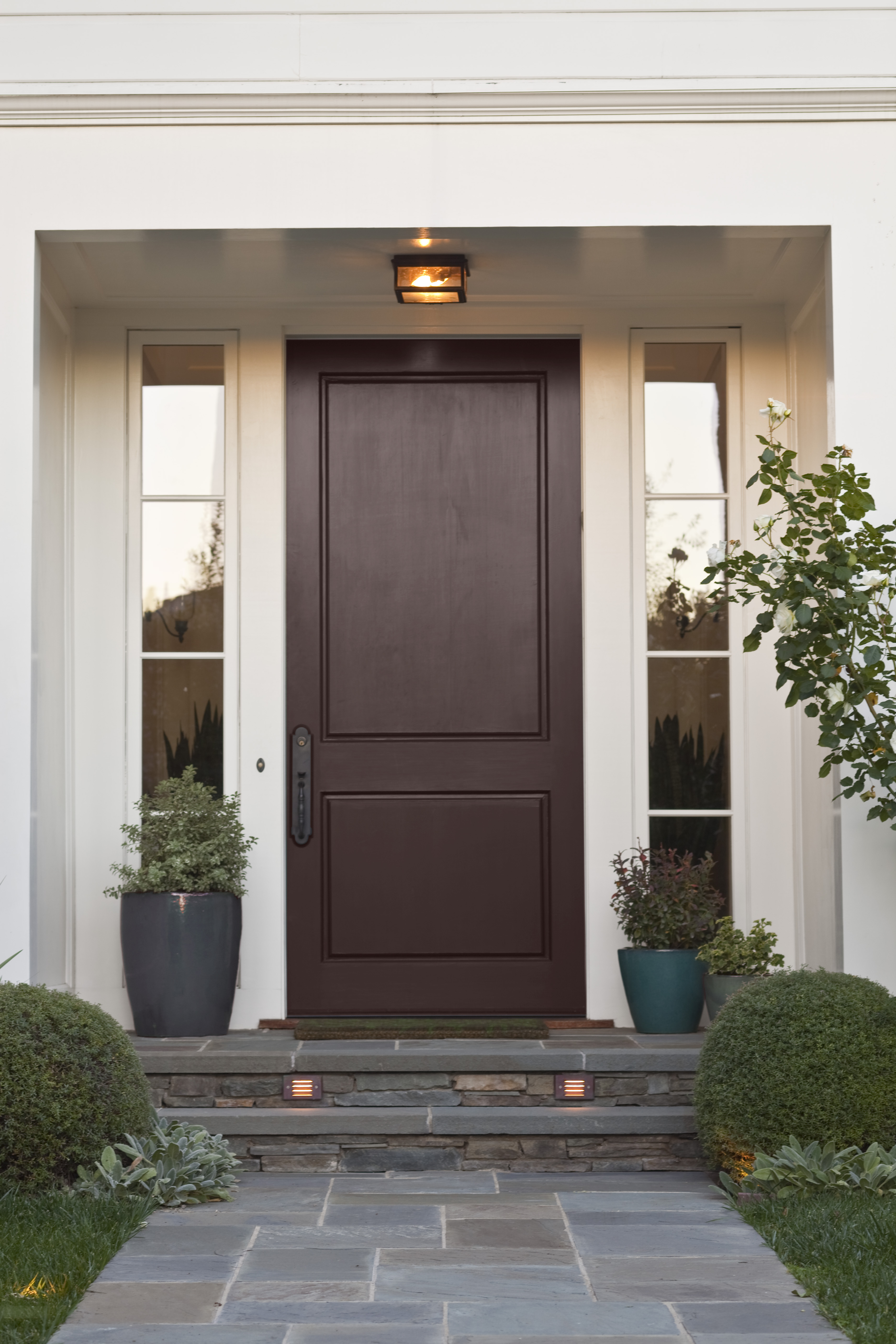 A house exterior with a door painted in a deep brown colour