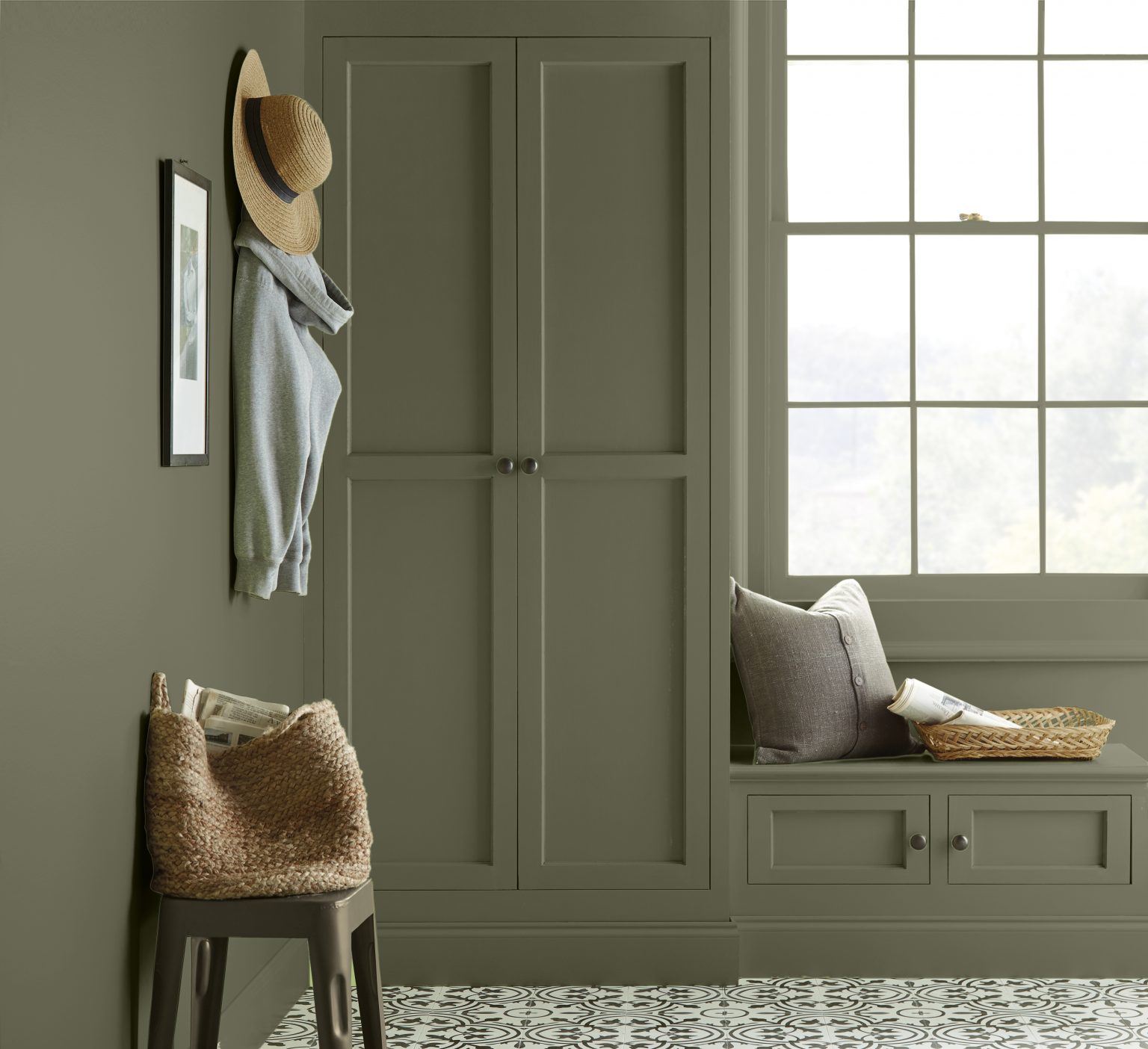 A built-in floor-to-ceiling reading nook with walls and cabinets painted in a dark olive green