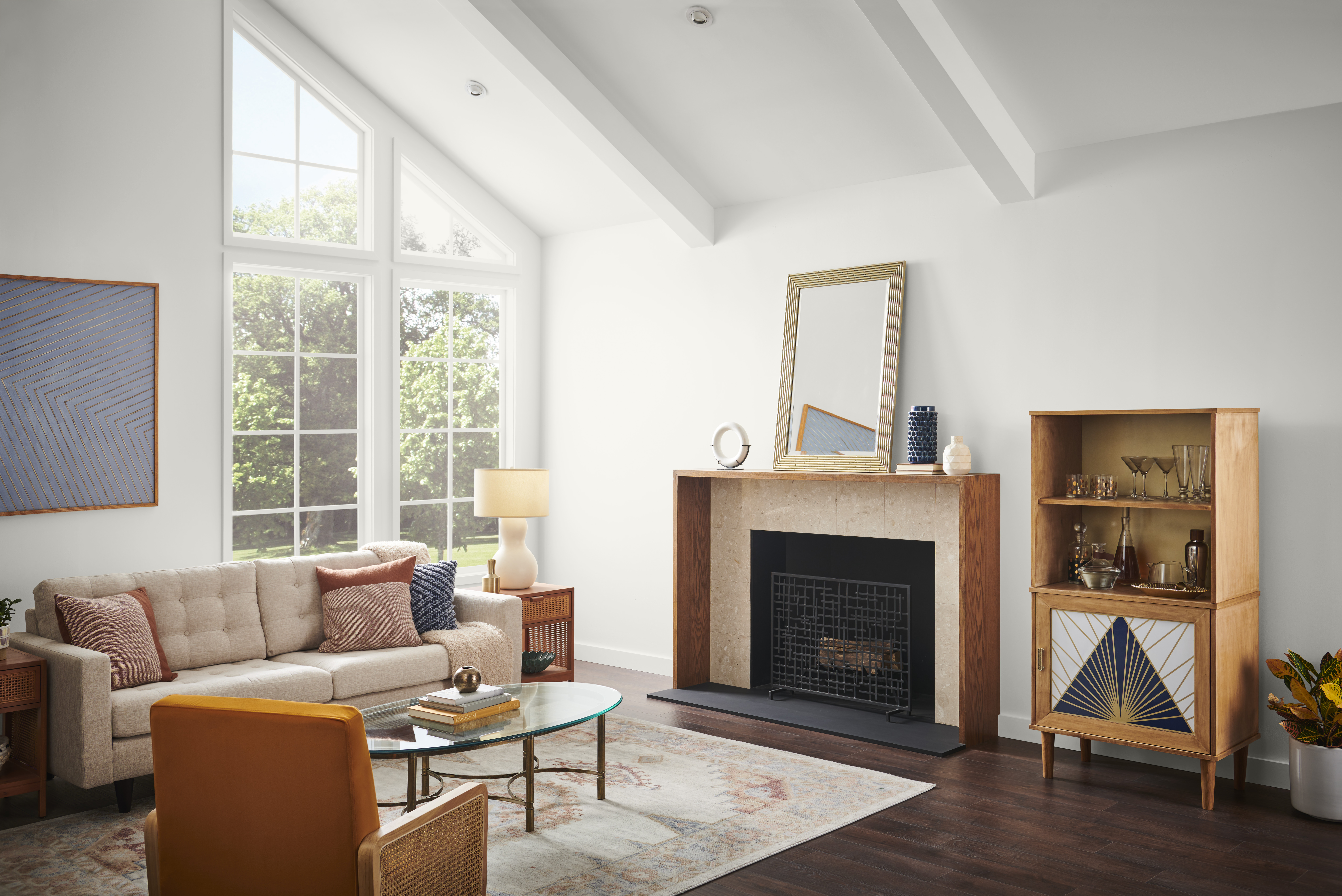 A spacious and bright living room with walls painted in white, contrasting with the dark wood floors and retro furniture