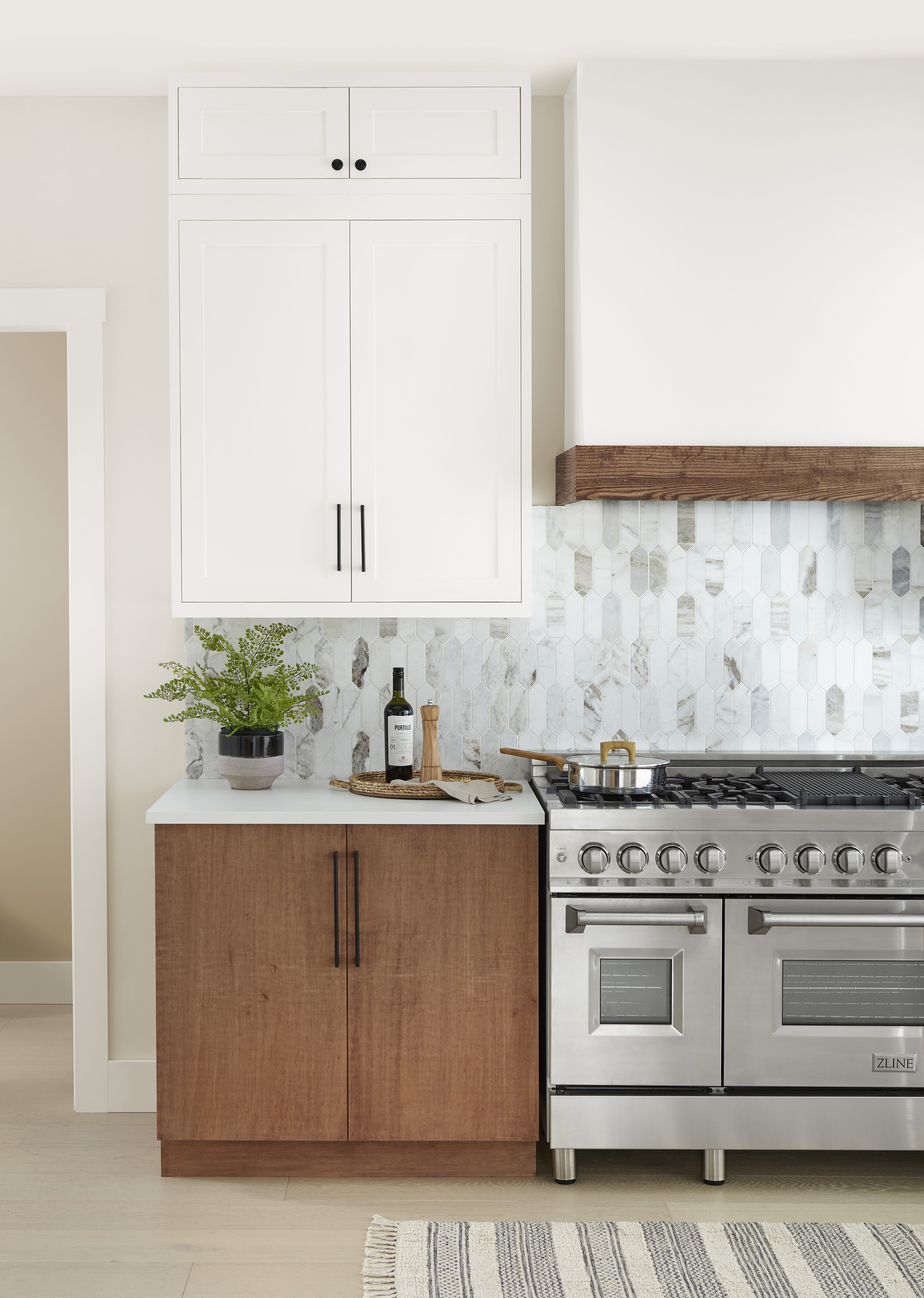 A closeup of a kitchen with upper cabinets and trim painted in white