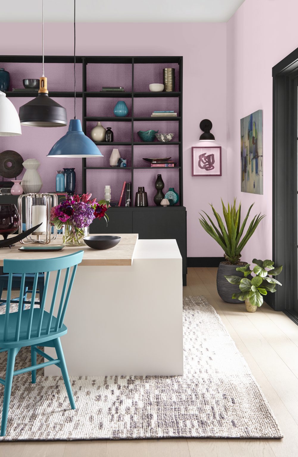 A dining area with walls painted in a pink-lavender colour and black built-in cabinets