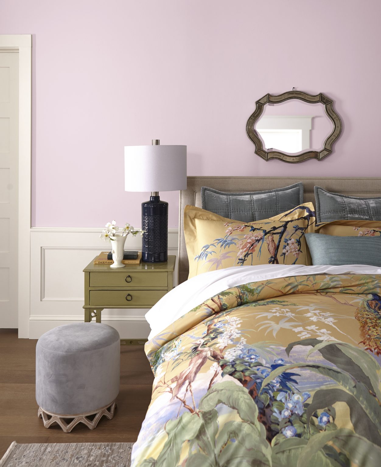A bedroom with walls painted in a pink-lavender colour and cream trim and board and batten
