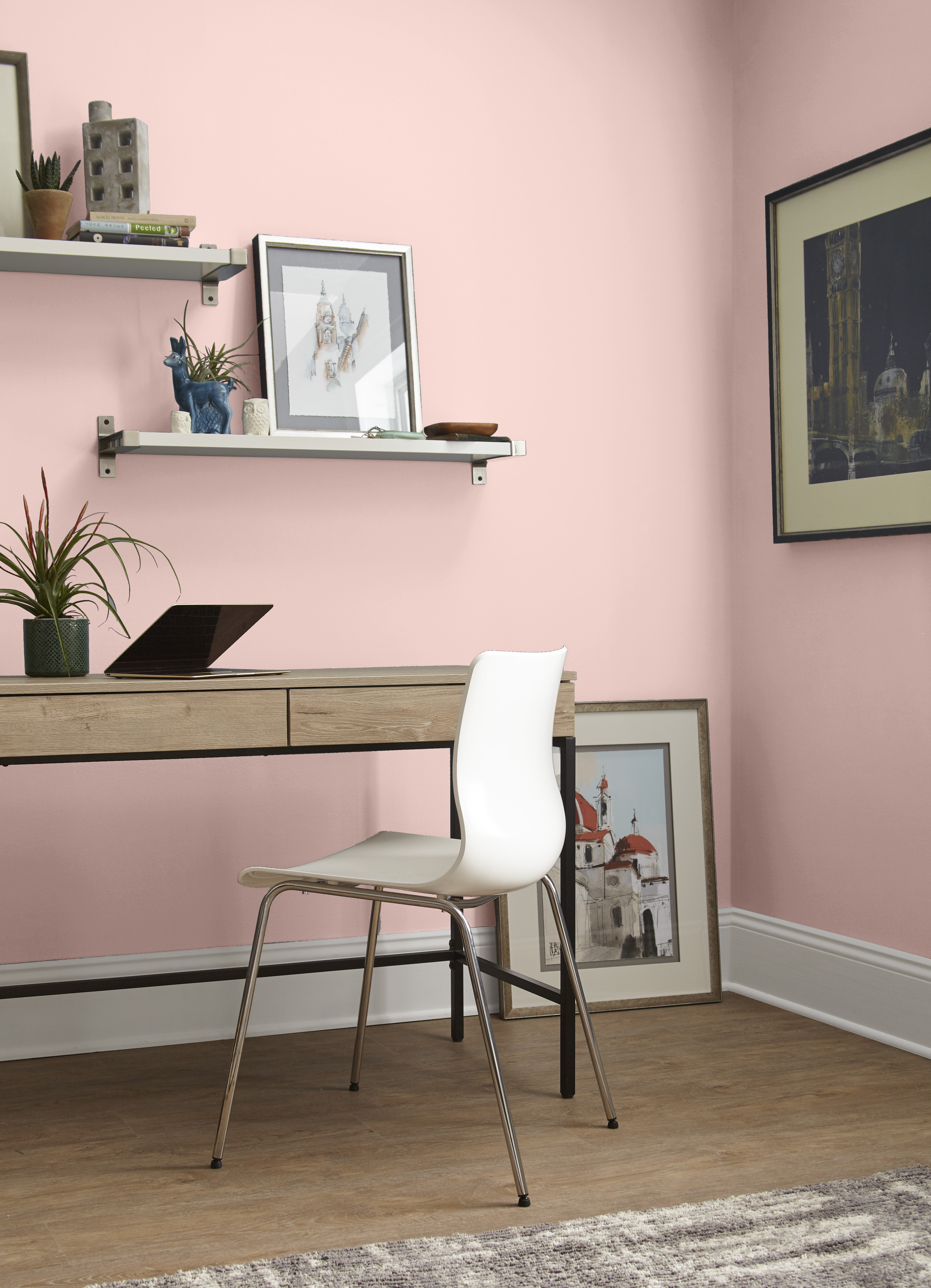 A home office area with walls painted in a light pink colour