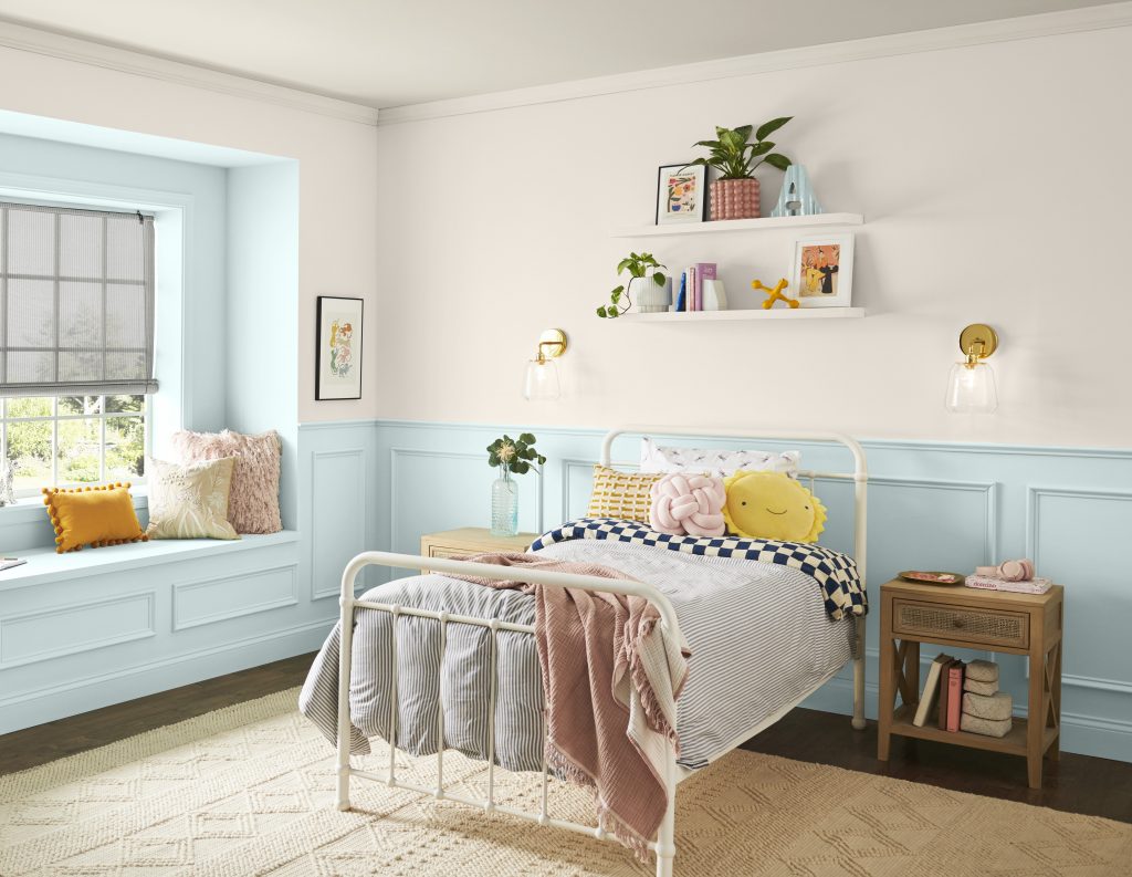 A kid’s bedroom with lower walls and a window nook painted in light blue 