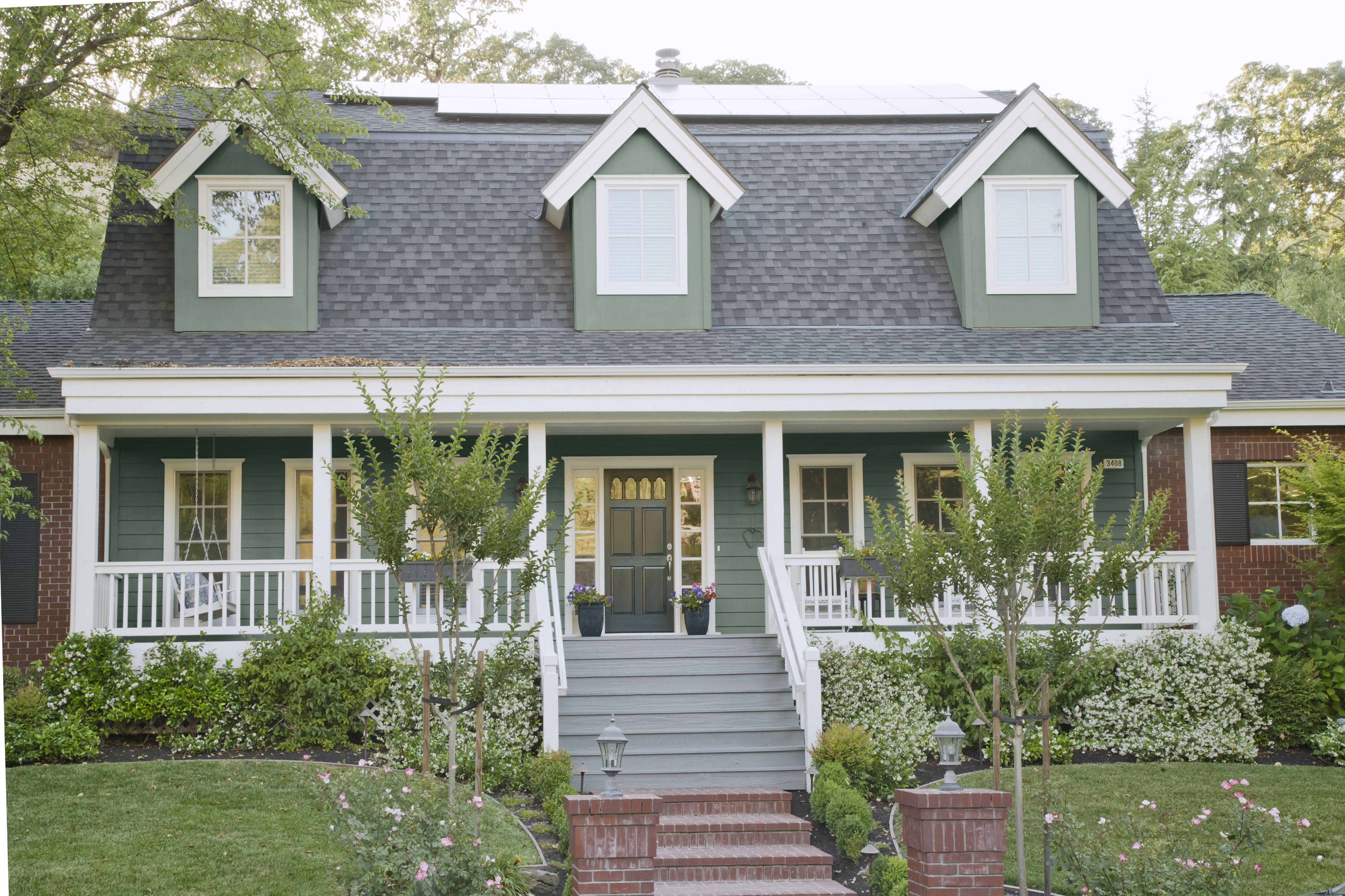 The front exterior of a house with siding painted in a greyish blue colour