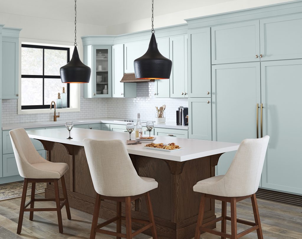 A kitchen with upper and lower cabinets painted in light blue 