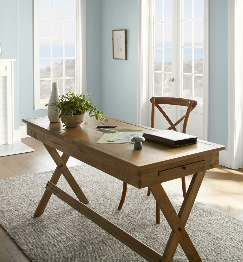 A bright home office with walls painted in light blue