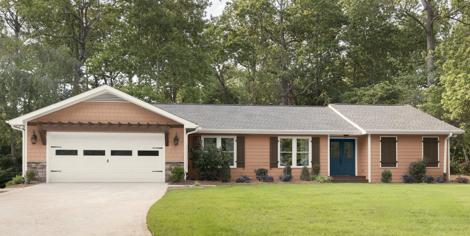 The exterior of a Ranch style house with siding painted in a light terracotta colour 