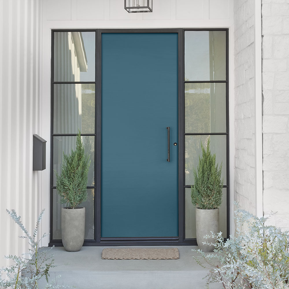 A modern farmhouse entry with a light purple-grey exterior, a blue front door, and dark charcoal grey trim, blending contemporary colour with classic farmhouse charm.