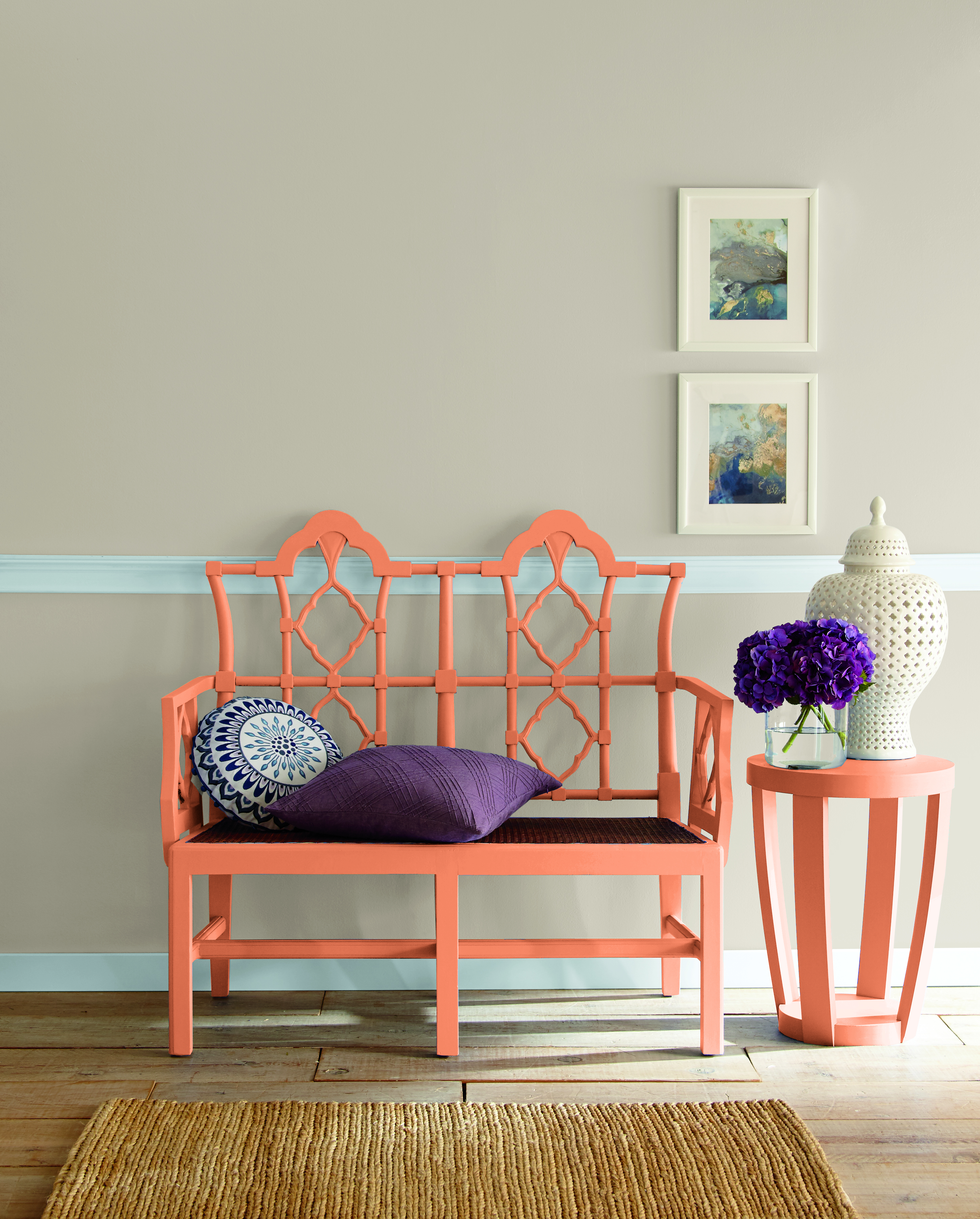 A hallway with a bench and side table painted in an orange hue.
