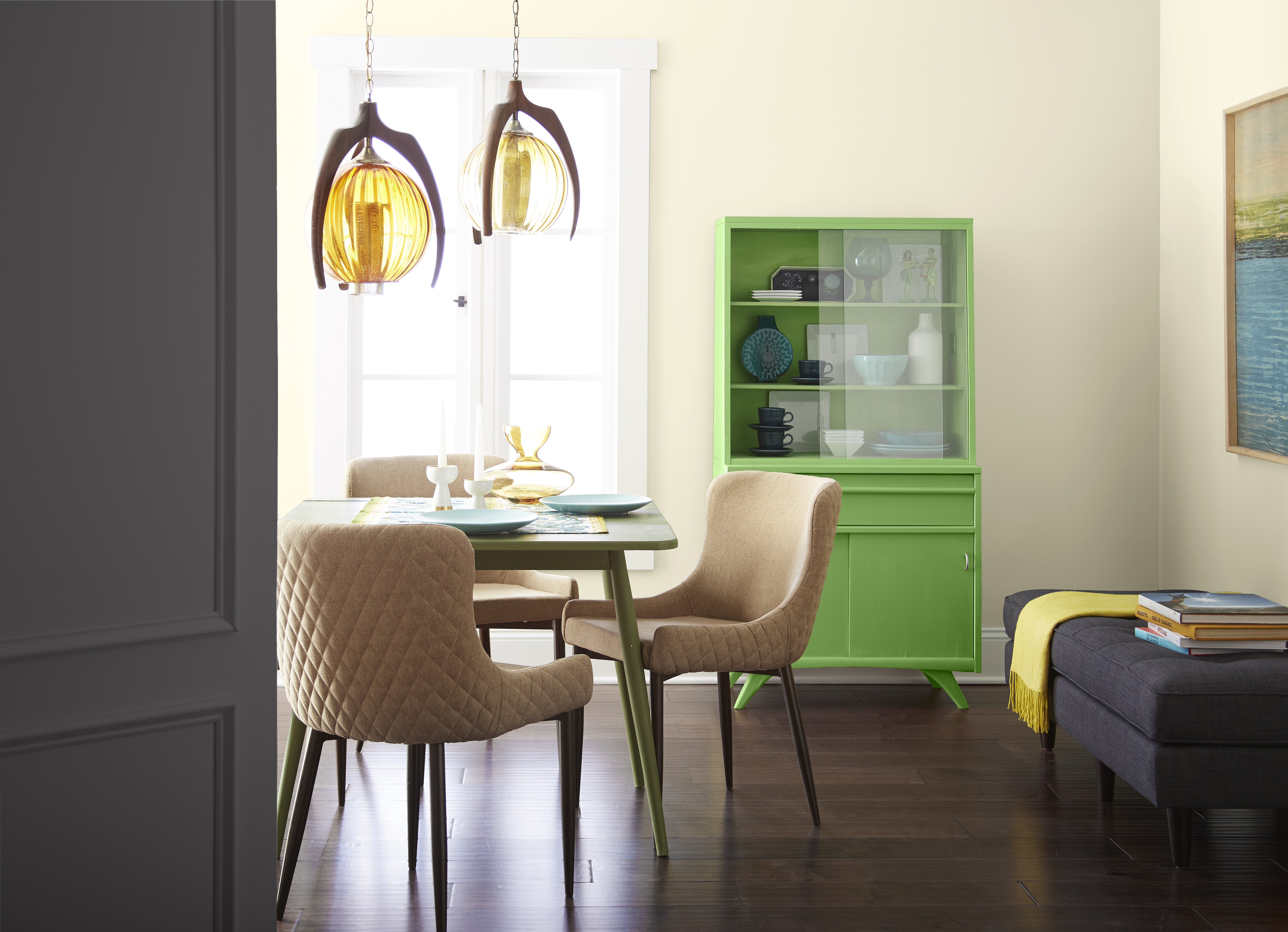 A small dining area with a light yellow hue for the wall and a pop of a bright green for the hutch.
