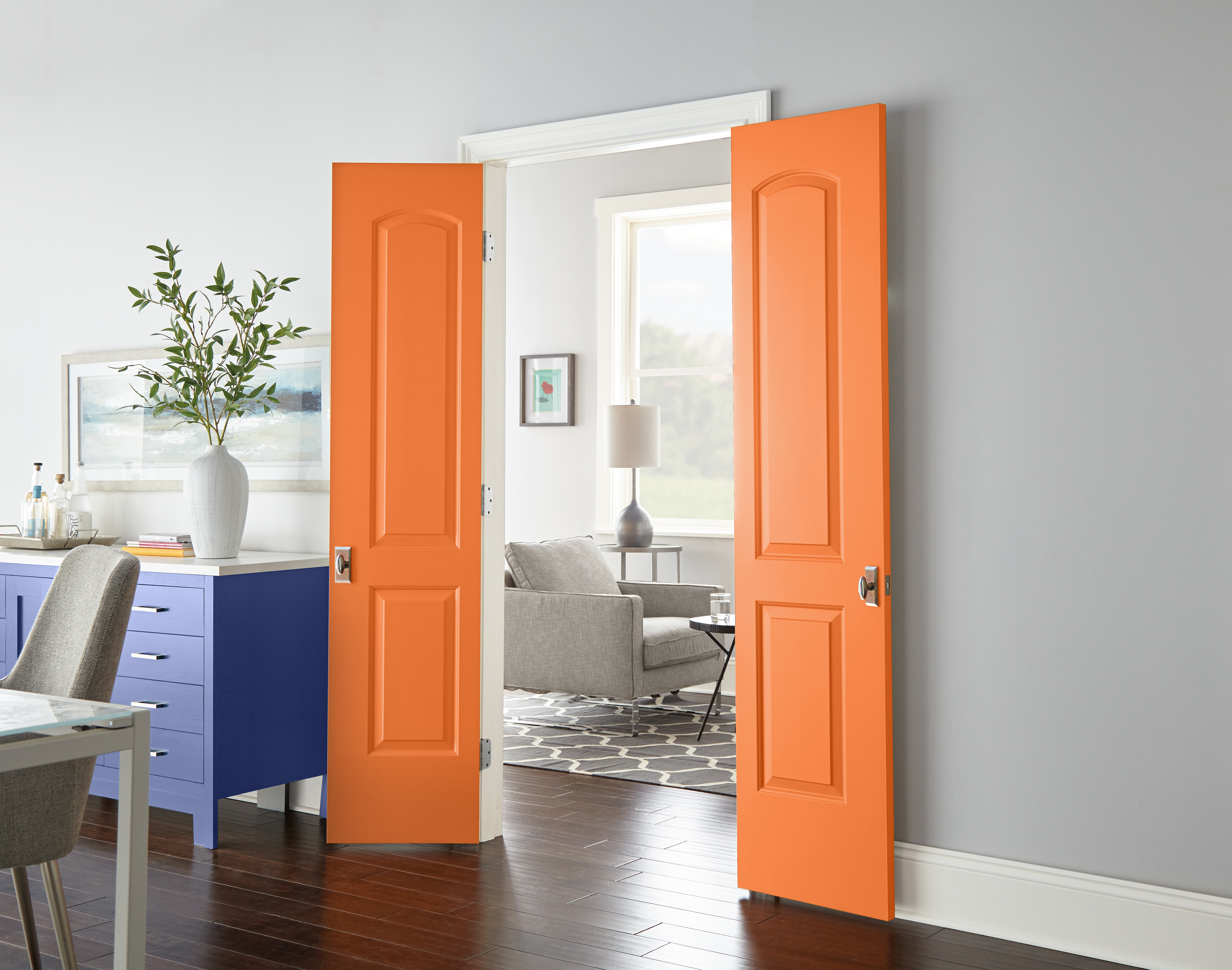 Bold, bright orange painted doors in a room with grey walls.