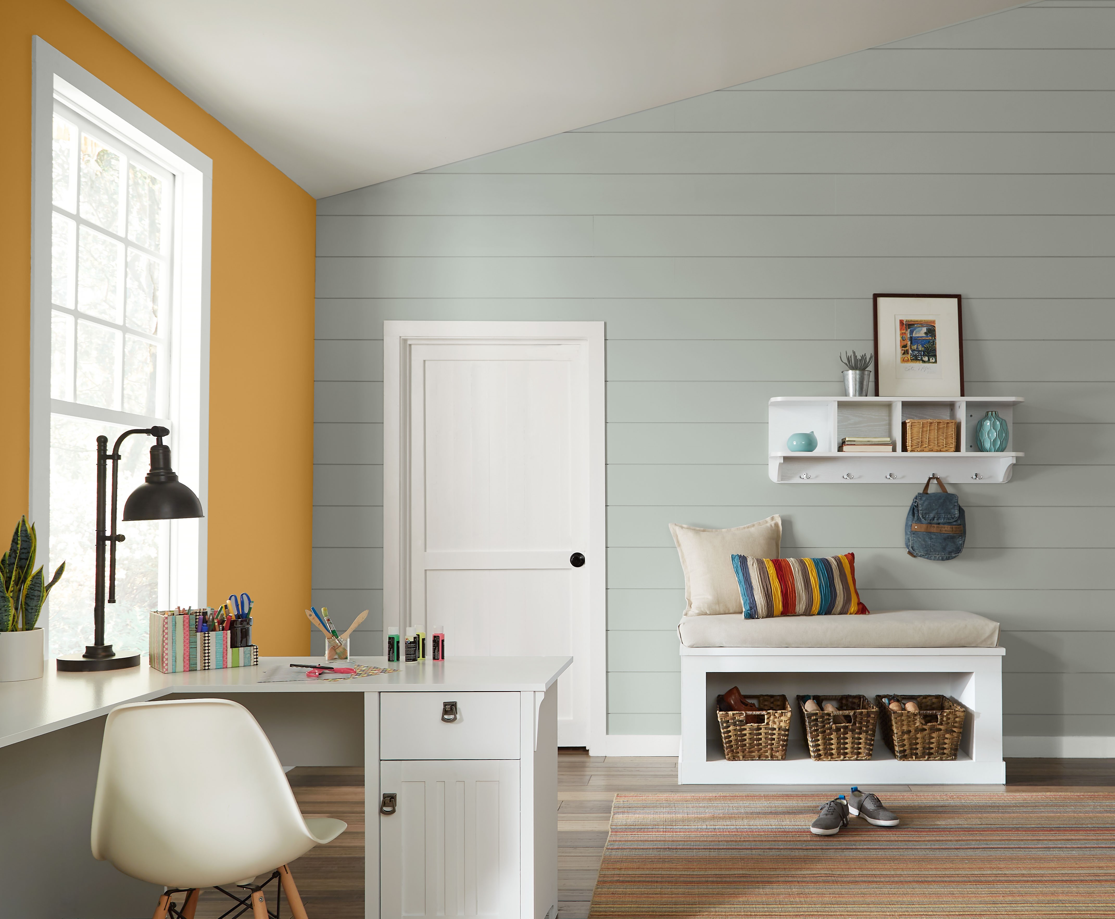 A multi-purpose room serving as a home office, kids’ playroom, and homework space, featuring a cheerful yellow accent wall that adds energy and warmth to the space.