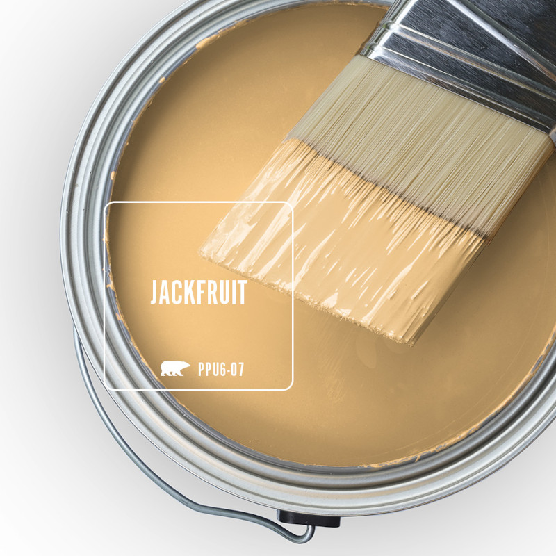 The top view of an open paint can filled with bright yellow paint, with a paintbrush resting across the rim, its bristles have partially been dipped in the paint.