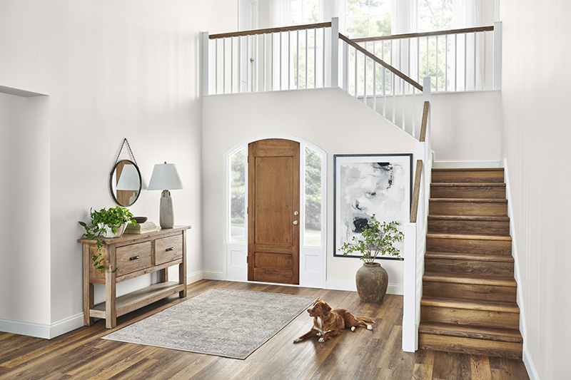 The image showcases a beautifully designed entryway with a staircase, blending elegance and warmth.