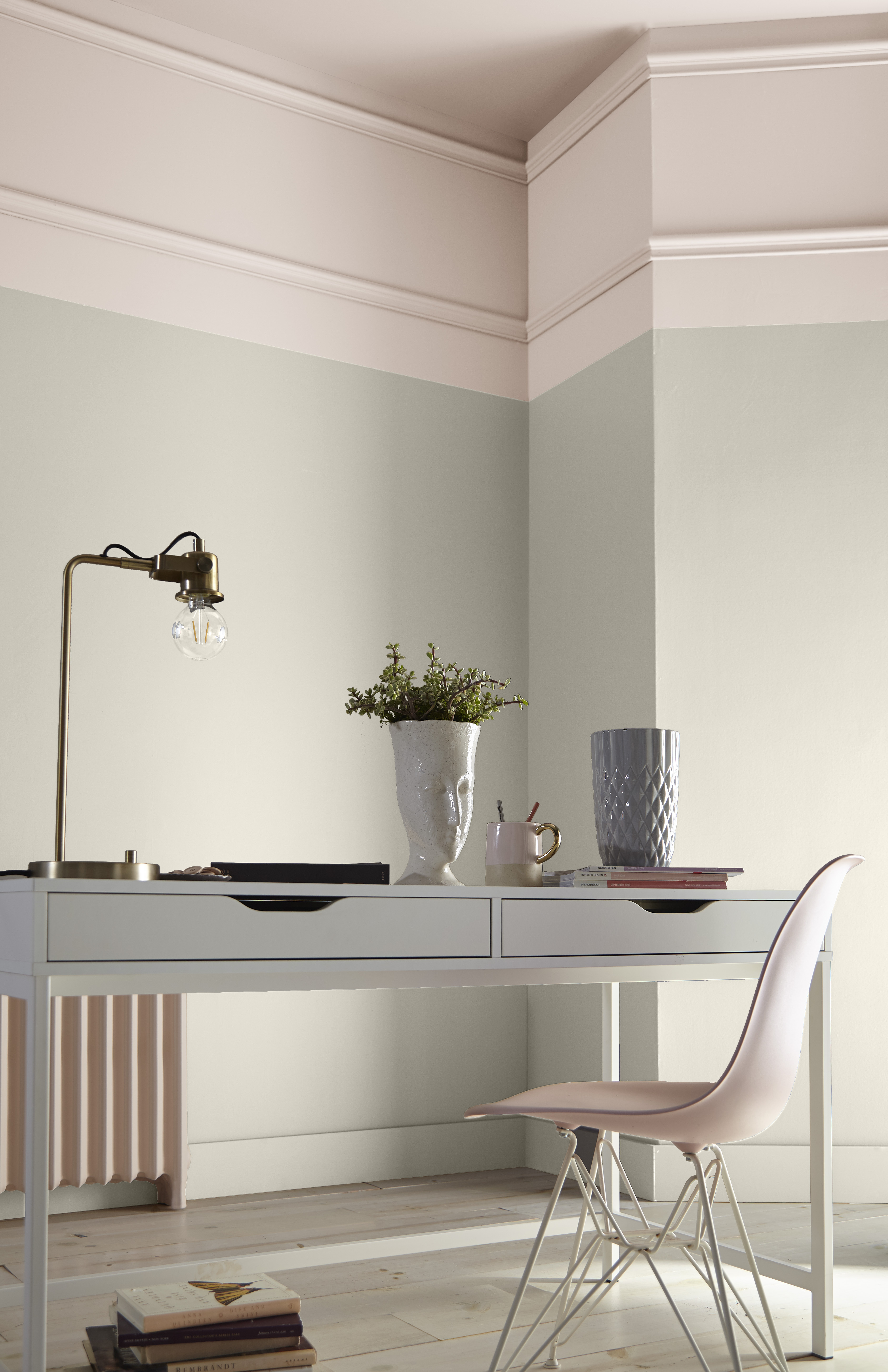 Modern study room with light pink ceiling and upper walls, light grey lower walls, white desk, and pink chair.