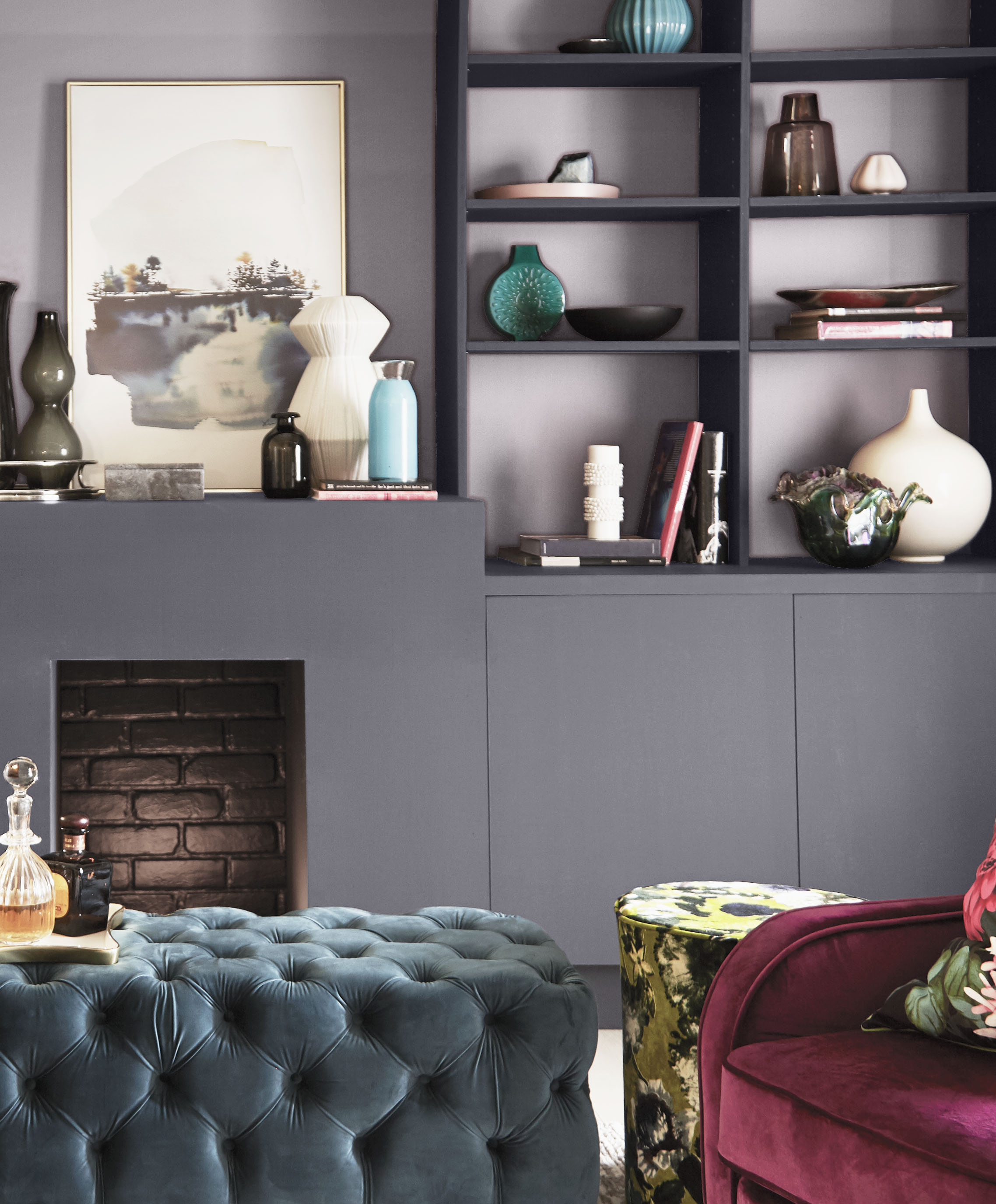 A living room with the fireplace and cabinets in a steely grey hue, while the backdrop of the shelves is in an elegant lavender grey.