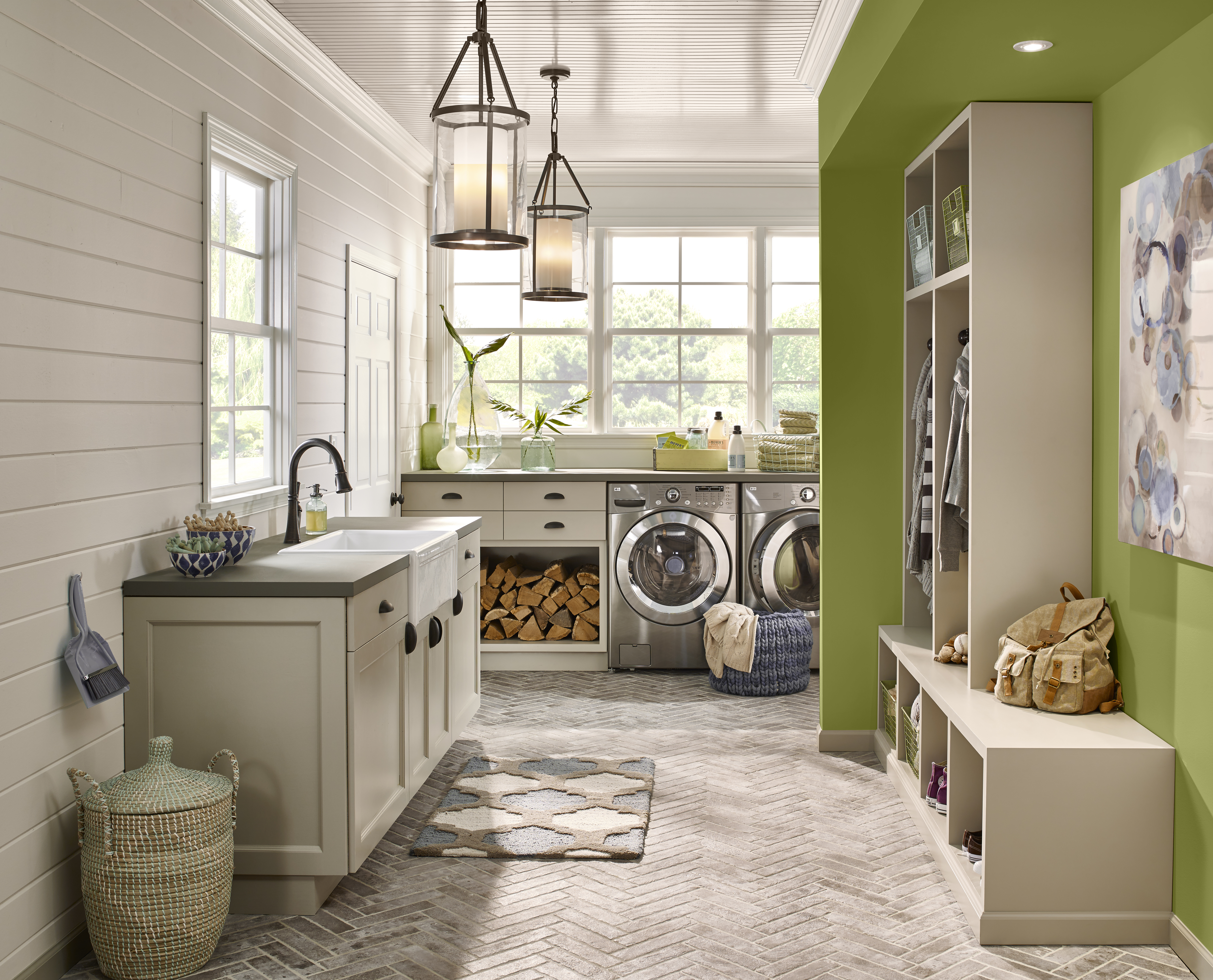 A laundry room and entryway of a home with walls painted in neutral hues, except for one wall that is painted in an earthy green colour.