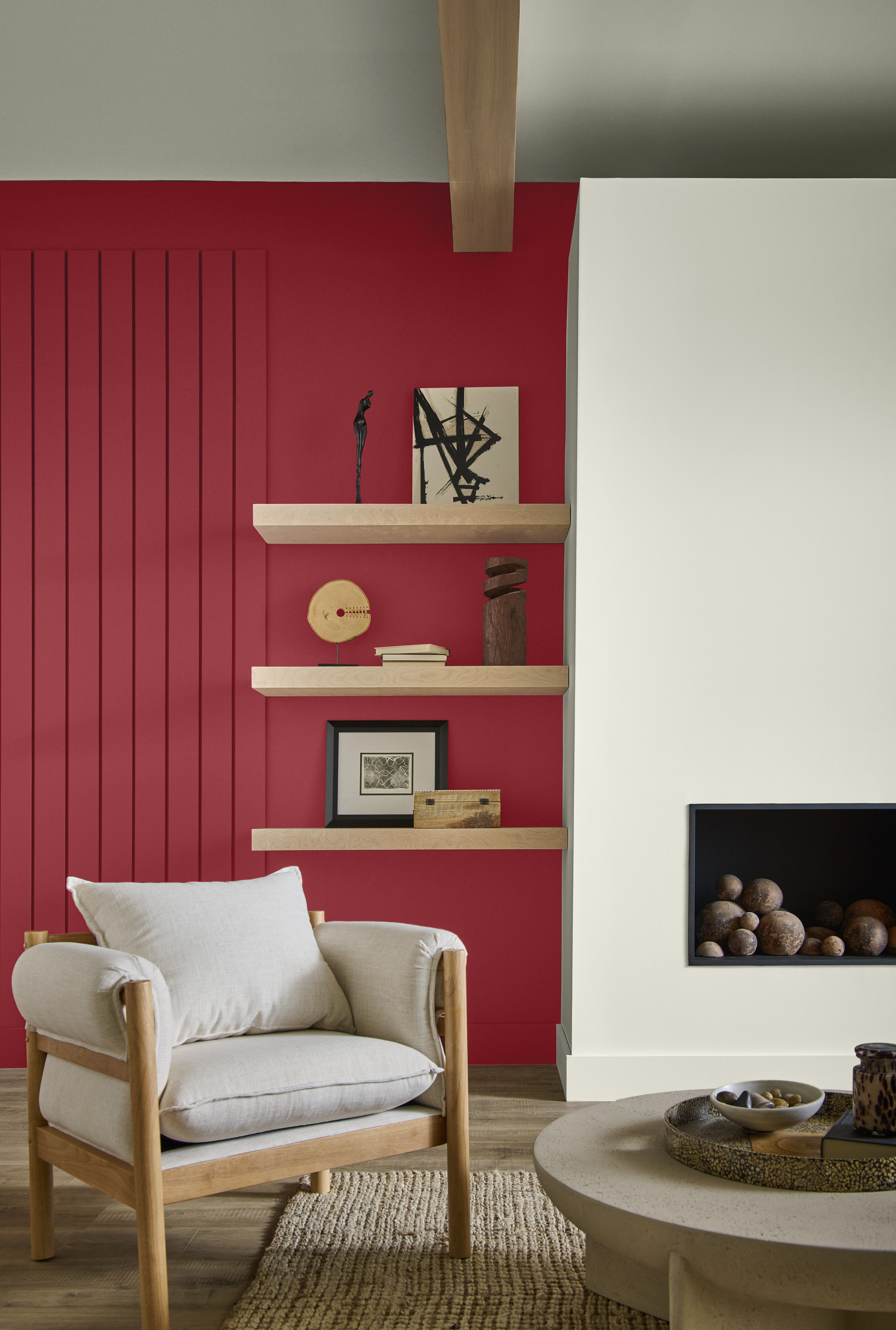 A living room with a fireplace in a soft white with surrounding wall in a warm red hue.