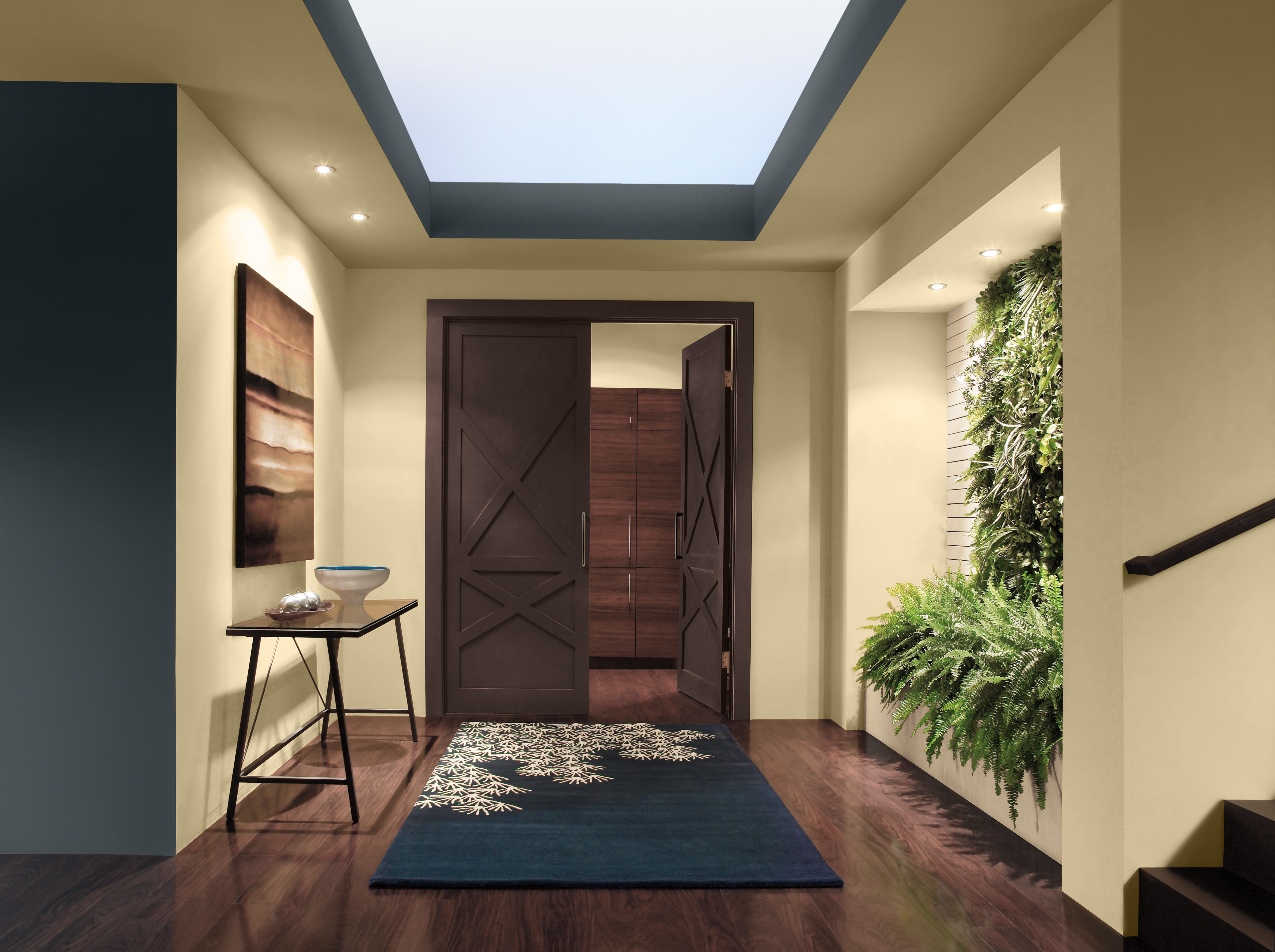 An entryway with a warm glowing yellow hue on the walls framed with an accent colour in a blended blue-black.