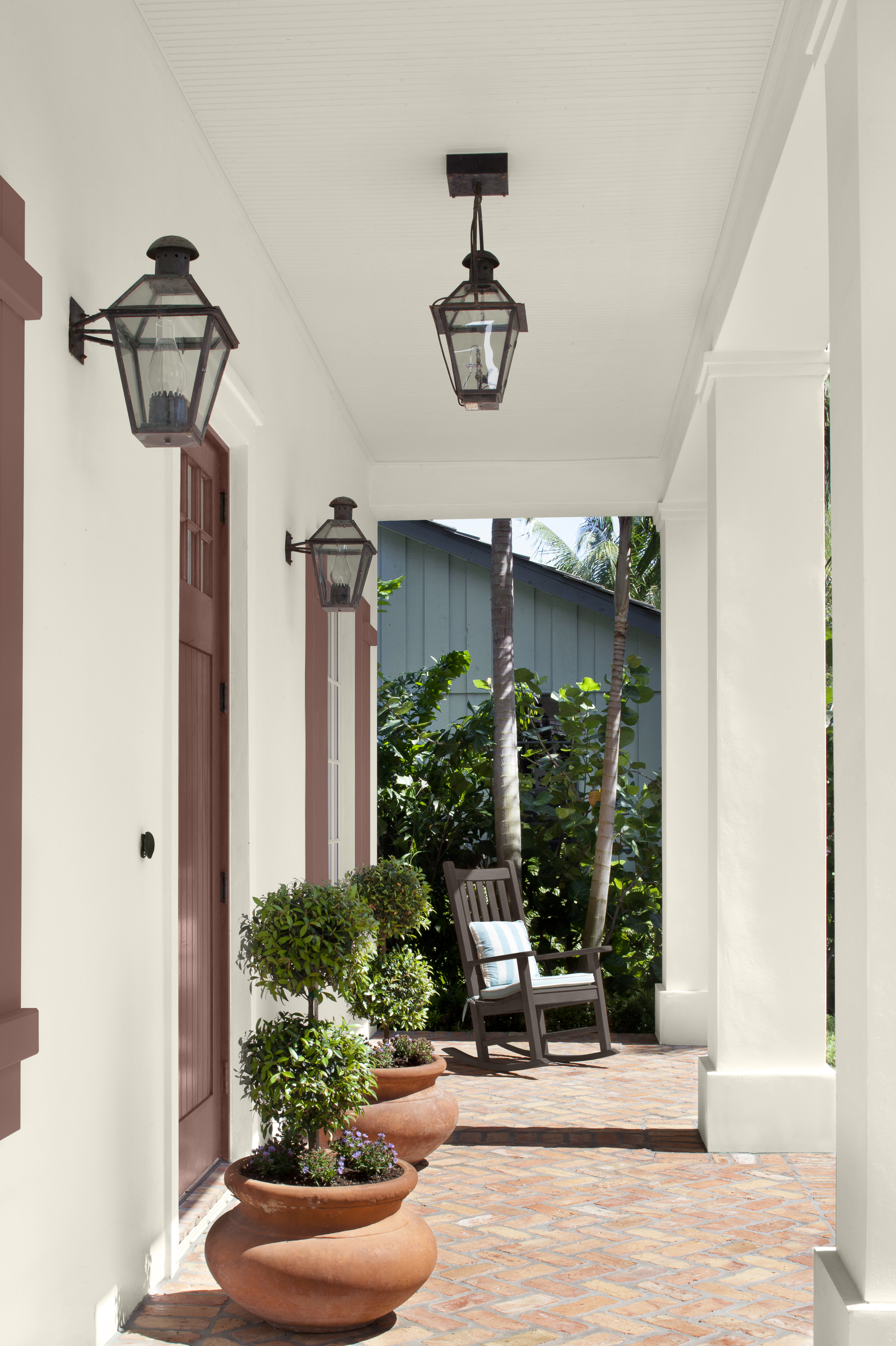 Alt text: A deep brown rocking chair sits in a quiet corner beside warm-toned accents.