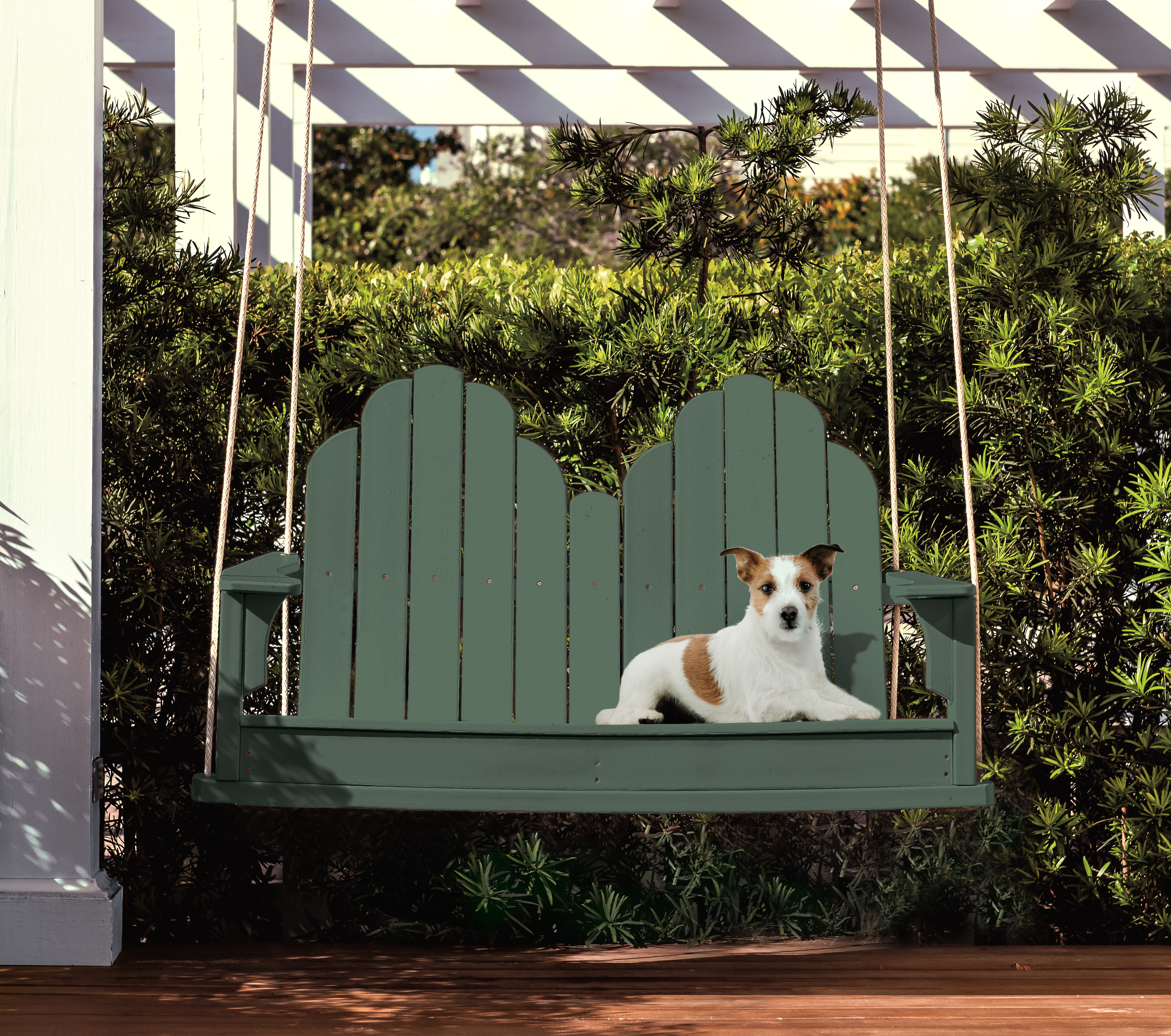 Alt text: A deep green swing bench blends into a lush garden setting.