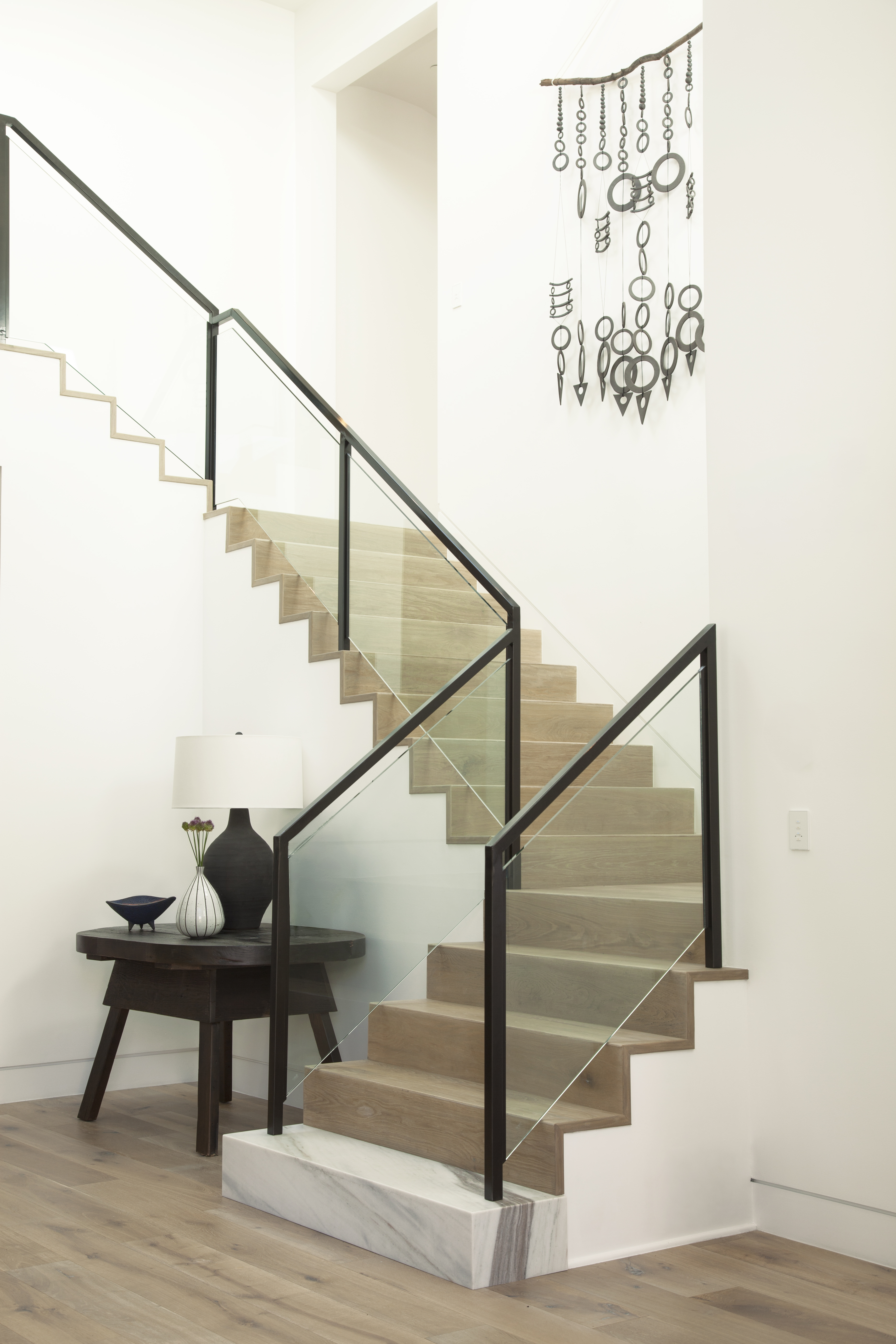 Bright stairway painted in warm off-white Twinkling Lights M280-1 with light wood steps and airy neutral styling.