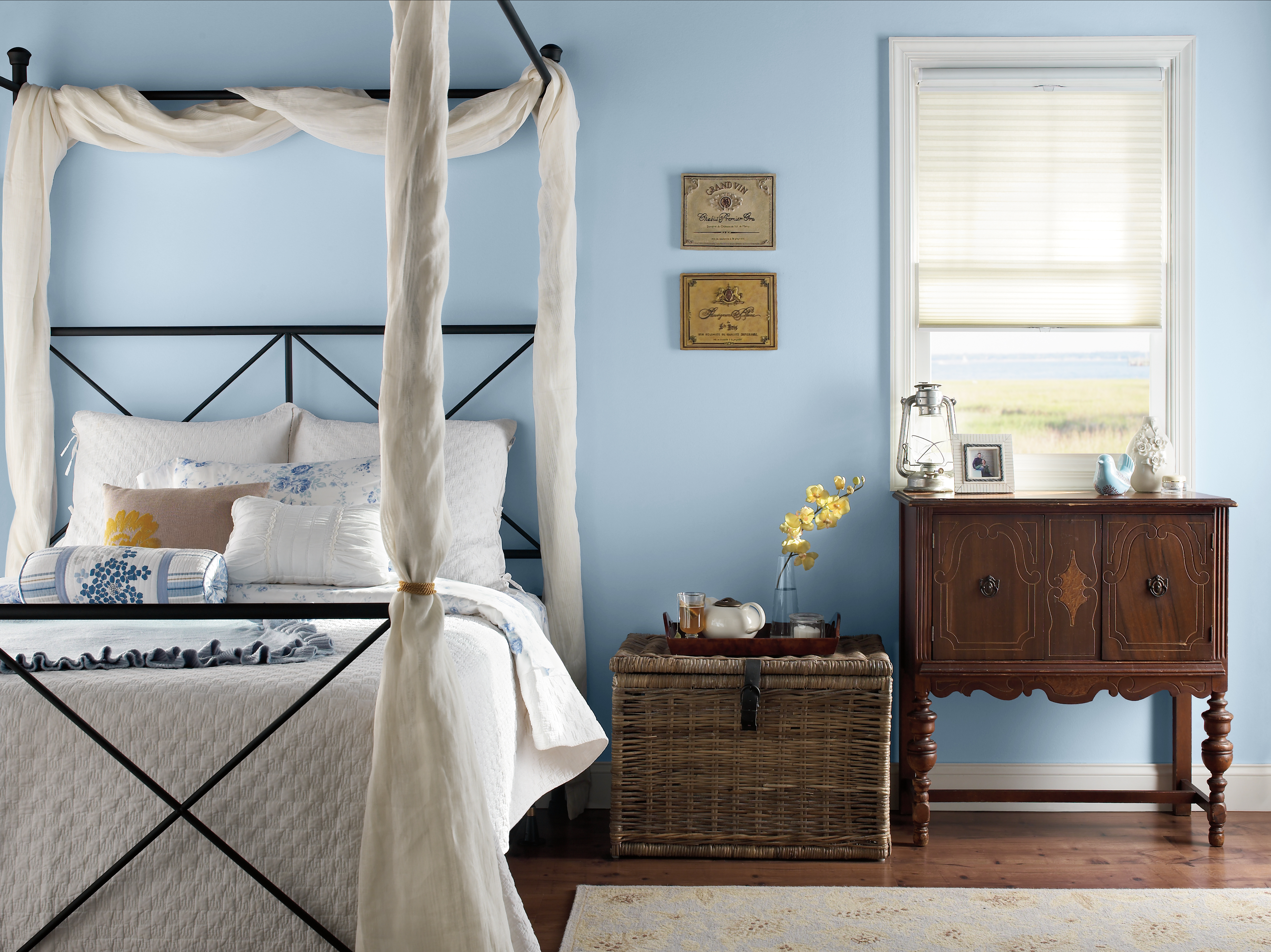 Serene bedroom with pastel blue Celestial Light MQ3-24 walls, soft white bedding and warm natural accents.