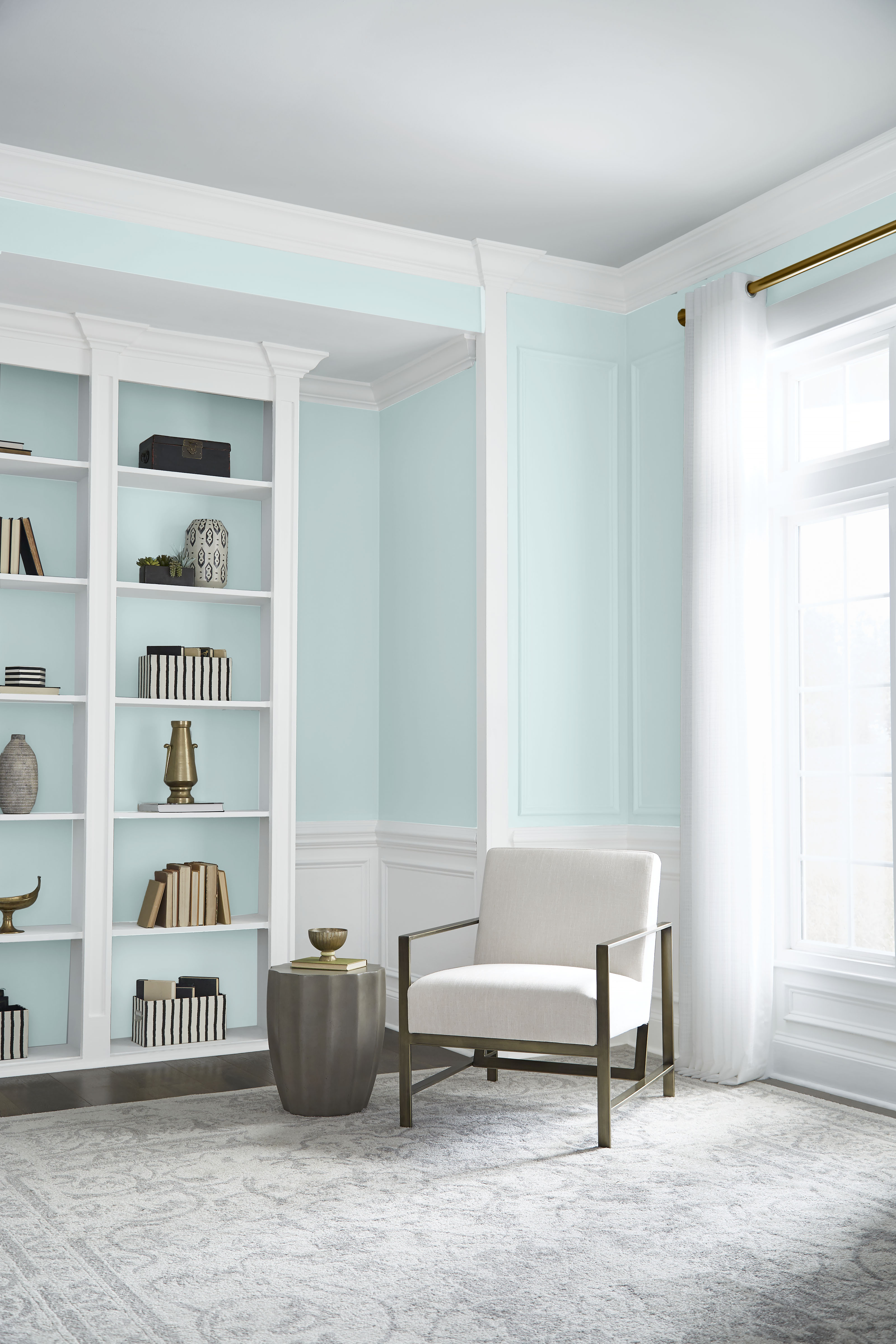Light-filled living room with airy blue-green Helium M480-1 walls, built-ins and soft neutral furniture.