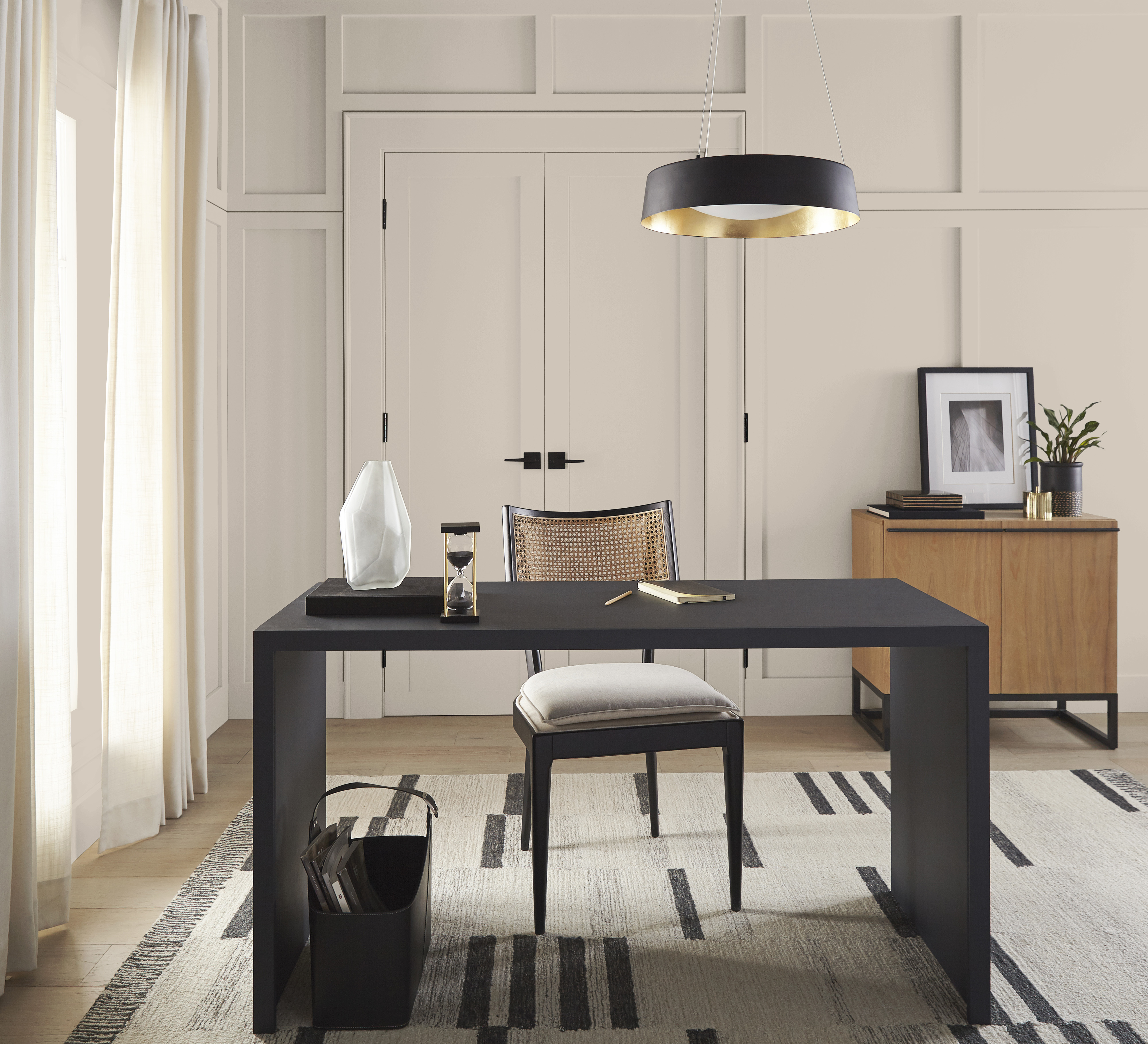 A home office with contrasting dark furnishings and layered natural textures add depth and dimension. The room feels sophisticated yet approachable, balancing productivity with comfort and making it a place where work feels both purposeful and inspiring.