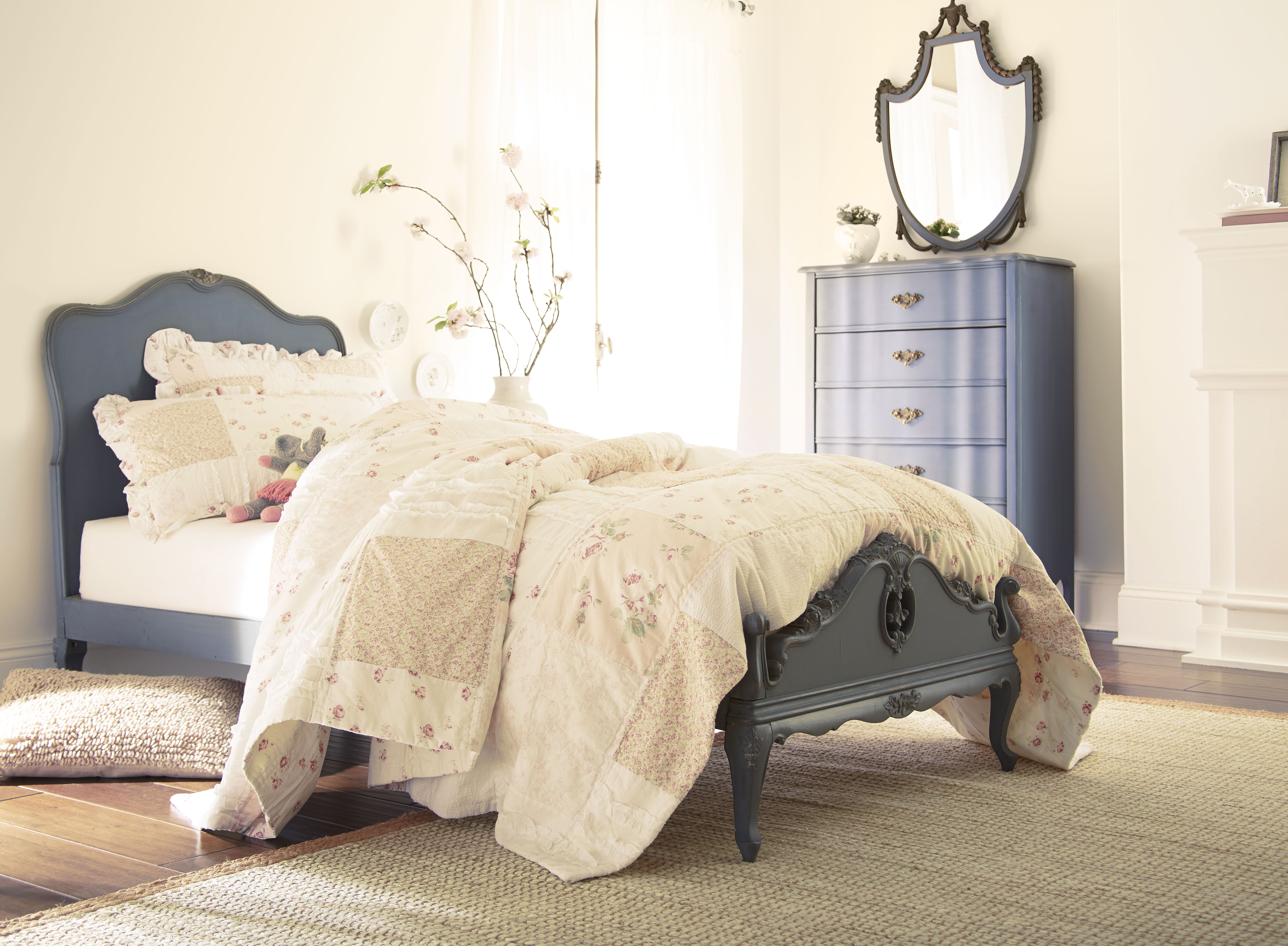 Bedroom with Polished Pearl cream wall paint, vintage-style bed, soft layered bedding, muted blue furniture accents, and natural light for romantic bedroom colour inspiration