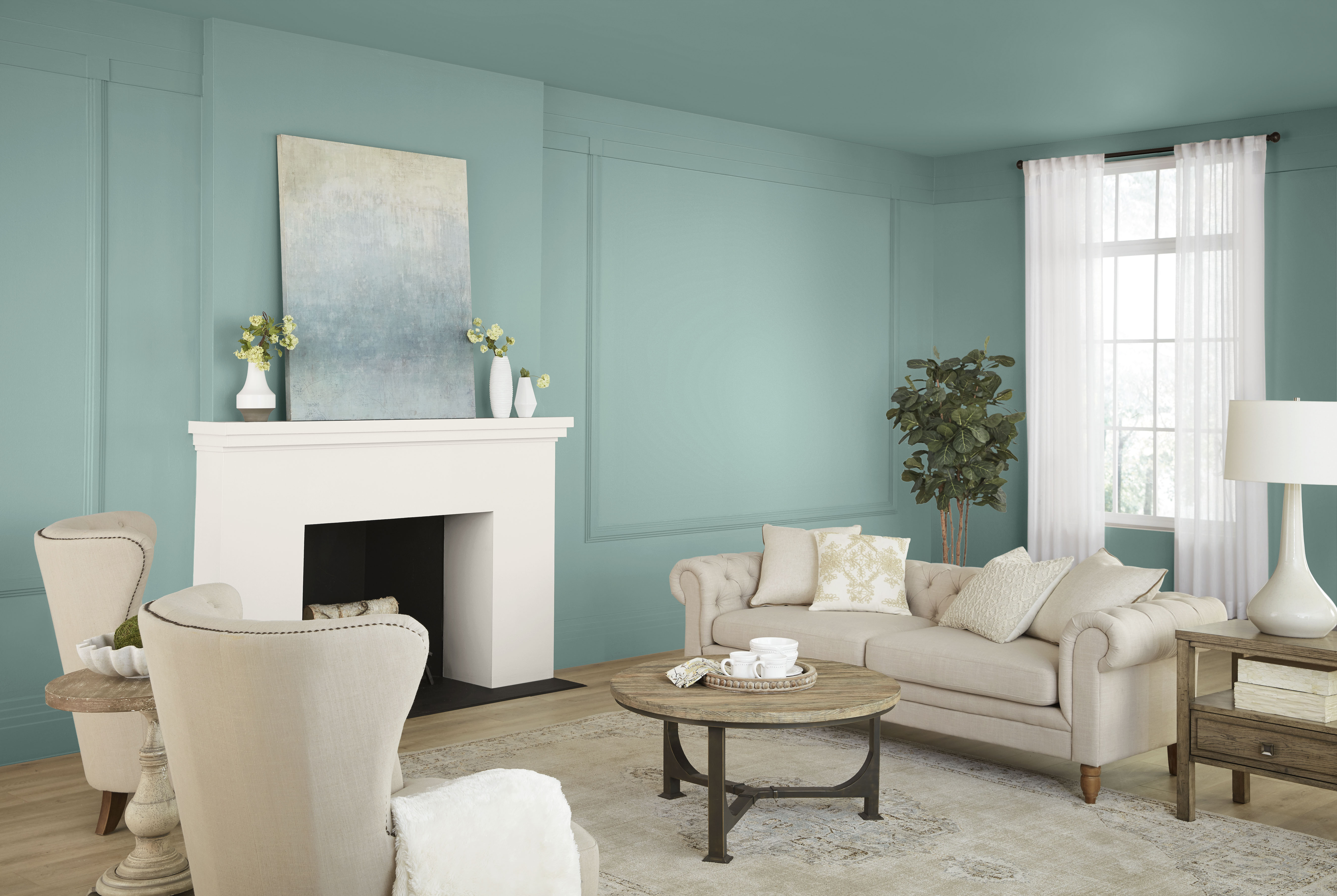 Living room with Opal Silk blue-green wall paint, white fireplace, neutral seating, natural textures, and warm wood accents for a soft romantic interior colour palette.