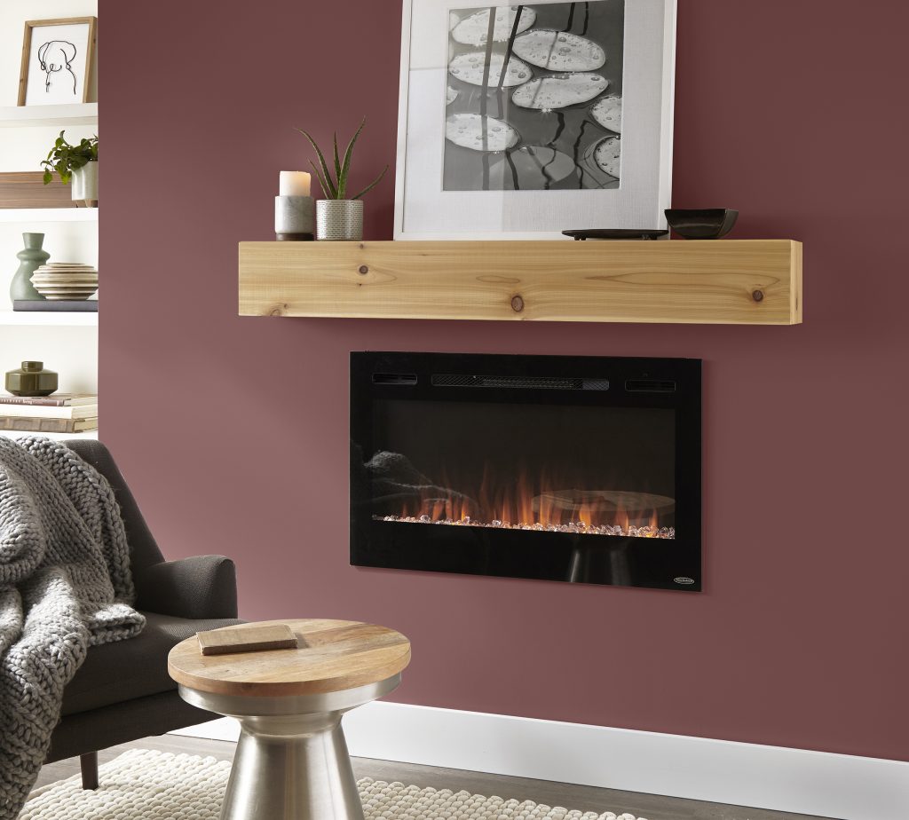 Fireplace wall painted Twinberry MQ1-14, paired with a natural wood mantel, black fireplace, neutral furnishings, greenery and soft grey textiles.