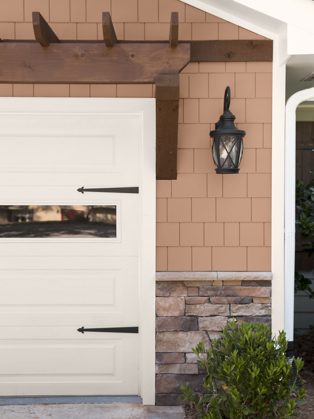 A tight crop of an exterior home showing a section of the white garage door. The exterior of the home is painted in Canyon Dusk with stone accents.