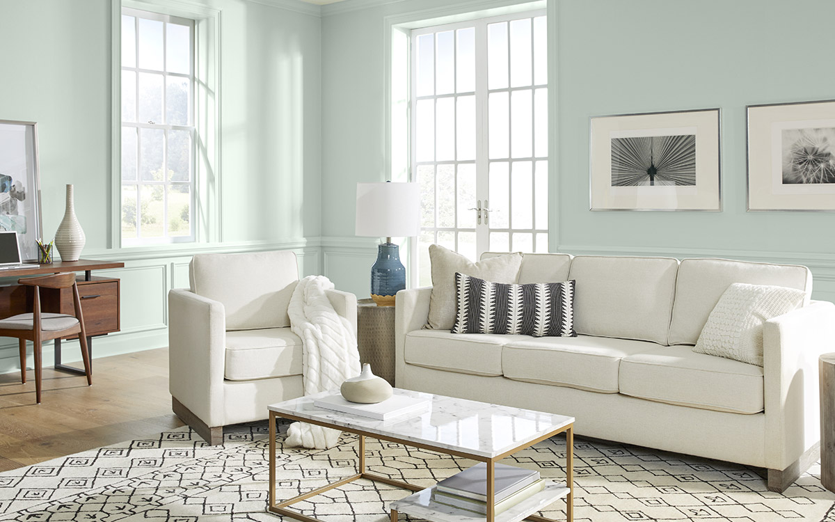 A living room with the walls painted in a soft sea glass green hue.