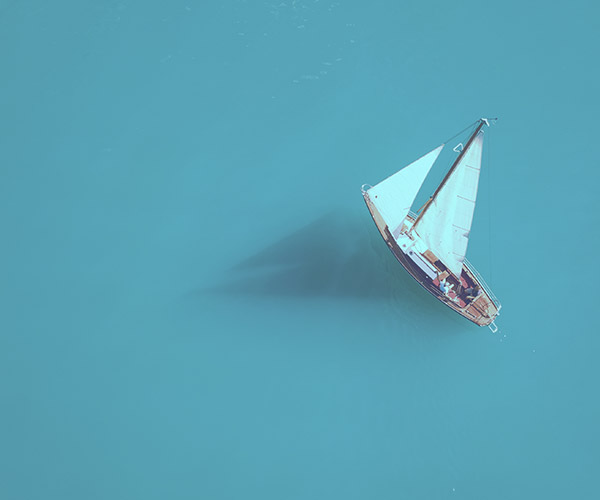 A sailboat on calm blue water.
